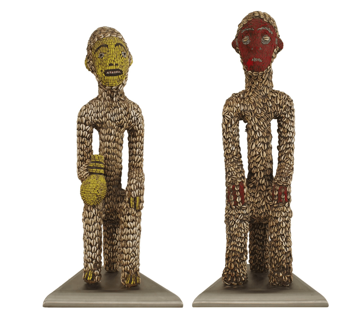 African fertility idol figures from the 20th century made of wood and adorned with cowrie shells