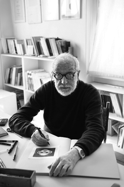 Italian designer Andrea Branzi sitting at his desk