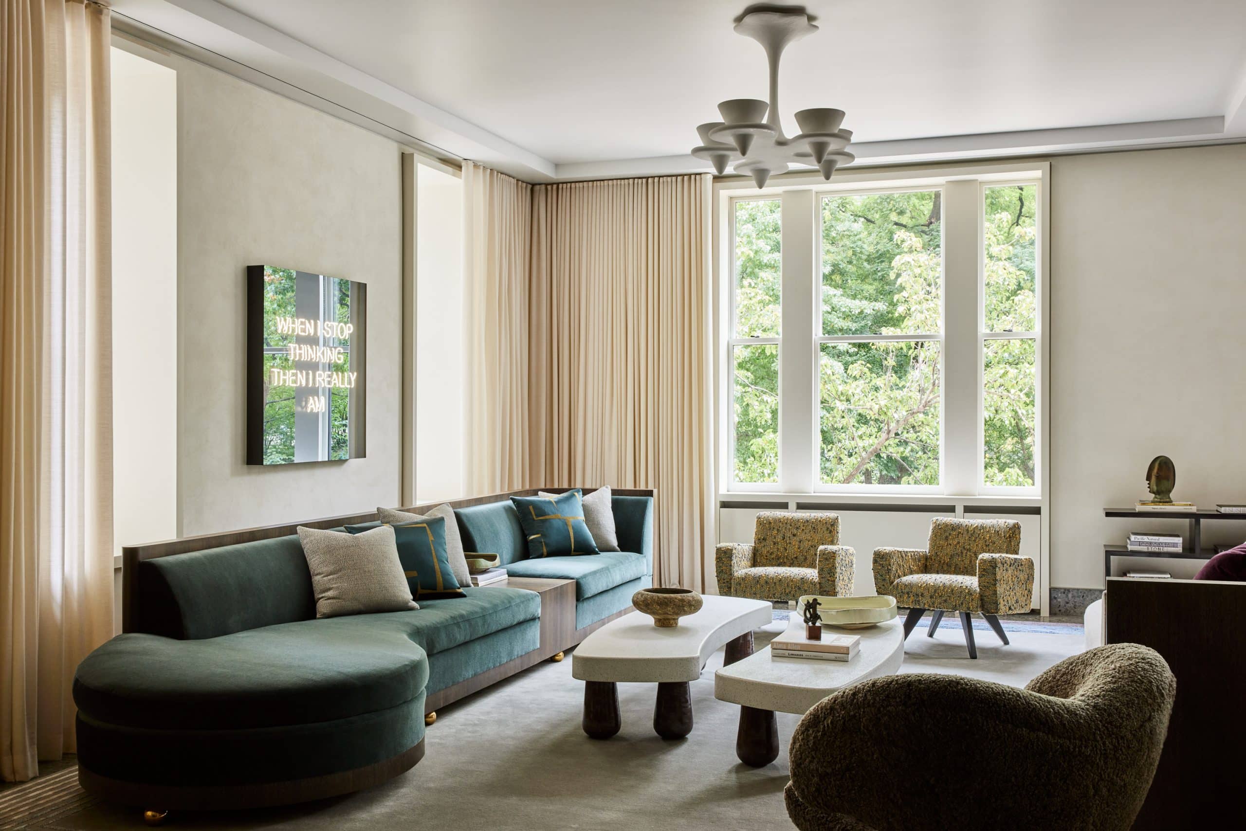 Overlooking the park is the formal living room, for which Schneider designed two large sofas in teal-blue mohair, with stained cerused-oak backs and copper ball feet. A pair of armchairs by José Zanine Caldas and a Viggo Boesen Petra chair, along with a coffee and a side table by Schneider, bestow a timeless ambience on the room