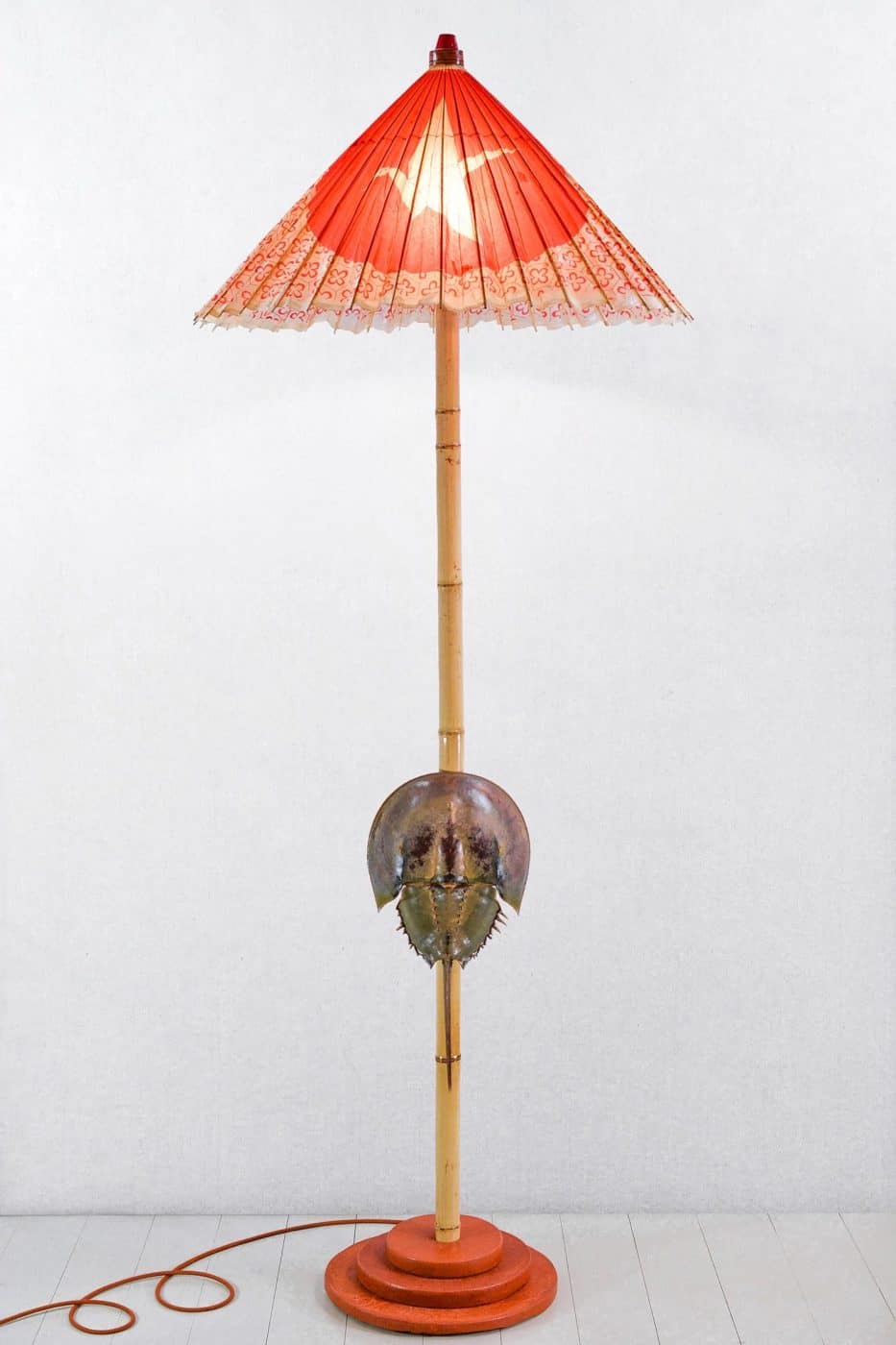 A Tennant New York floor lamp with a parasol shade and a bamboo shaft bearing a horseshoe crab shell