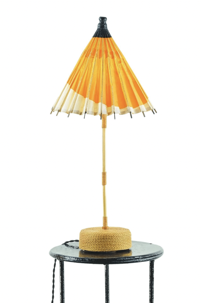 A Tennant New York table lamp with an orange-and-white parasol for a shade