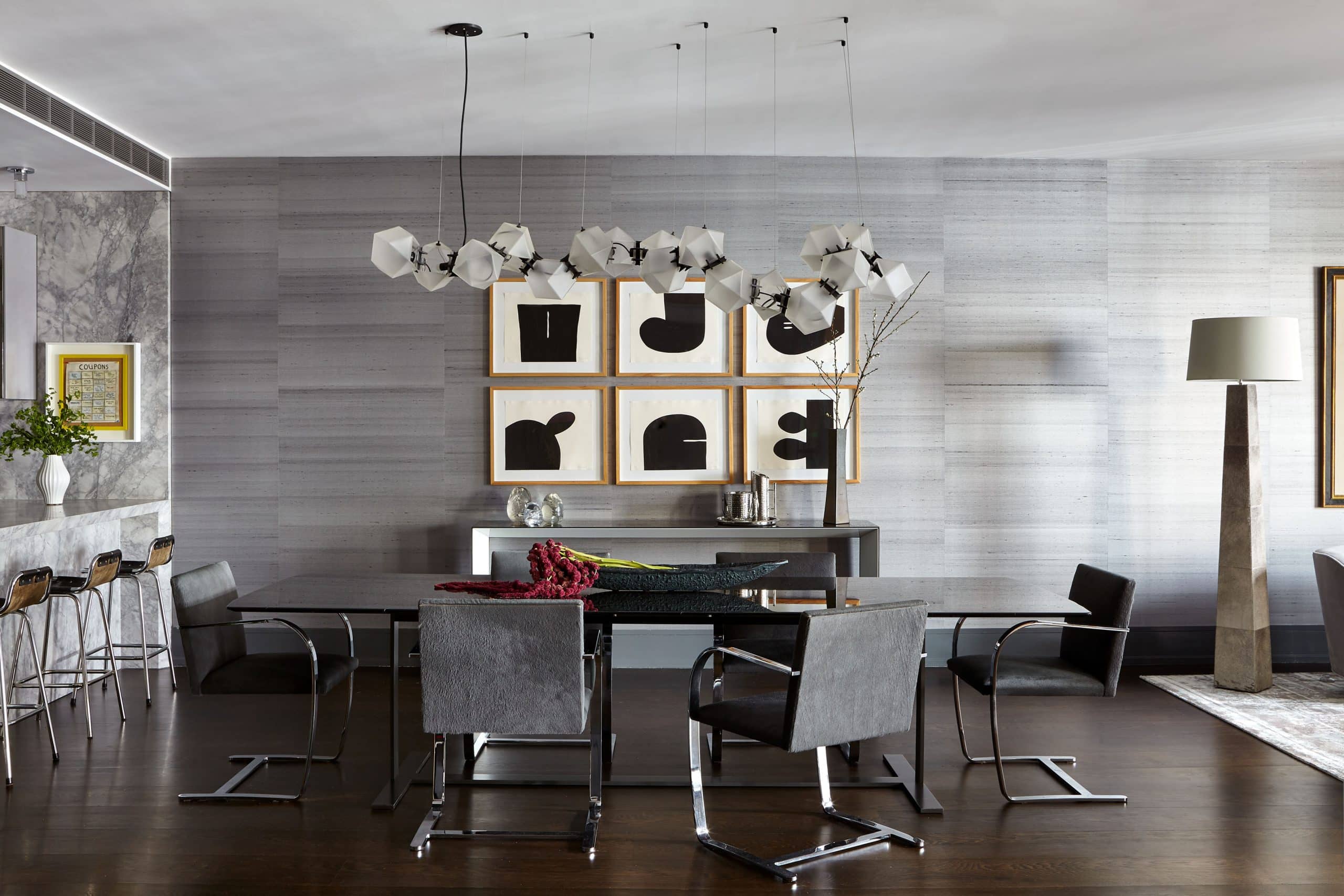 Dining room of Soho apartment with gray panelling, art and modern furniture, designed by Judy Dunne