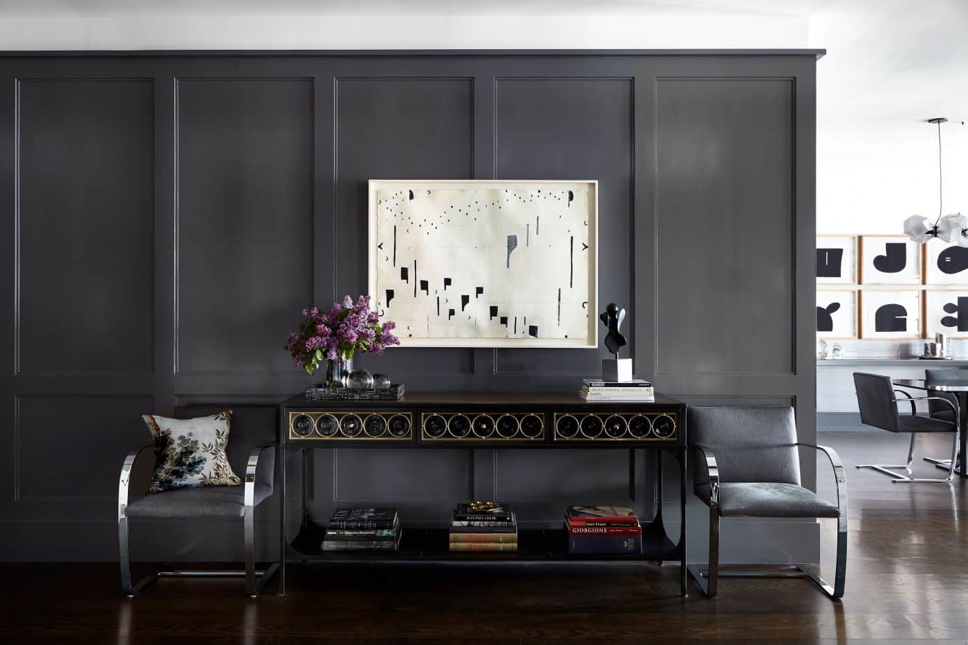 entrance hall of Soho apartment designed by Judy Dunne with gray panelling, art and modern furniture