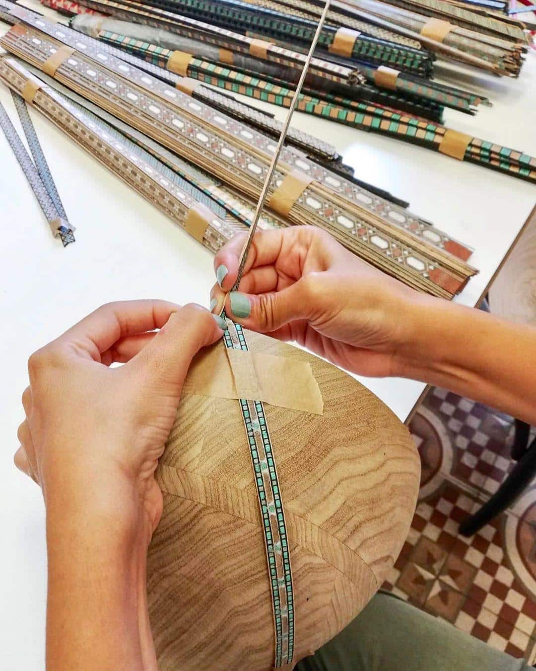 Nada Debs Marquetry Mania inlay process with hands inserting the thin strips of decoration.