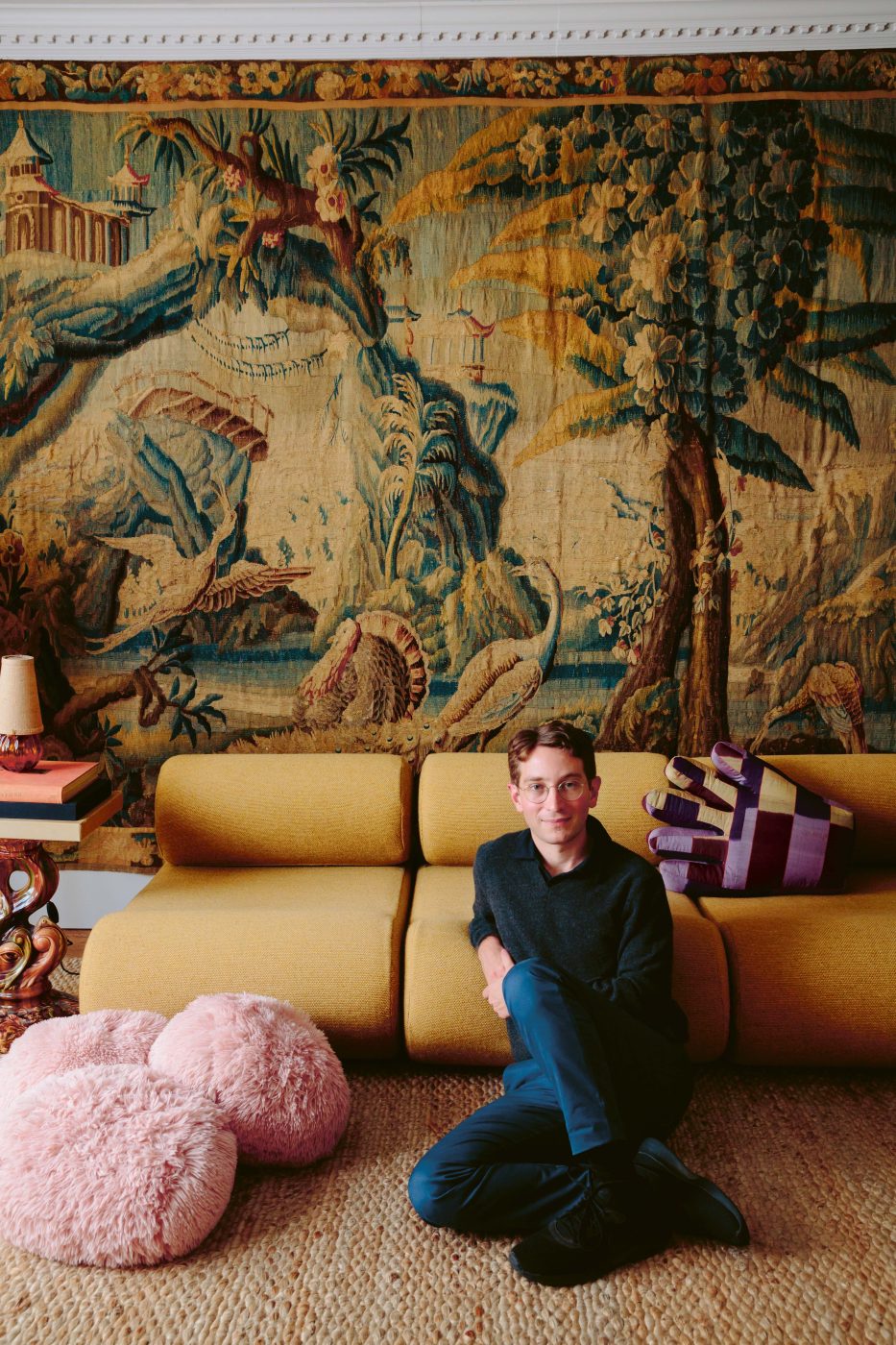 Designer Adam Charlap Hyman sits in his Manhattan living room