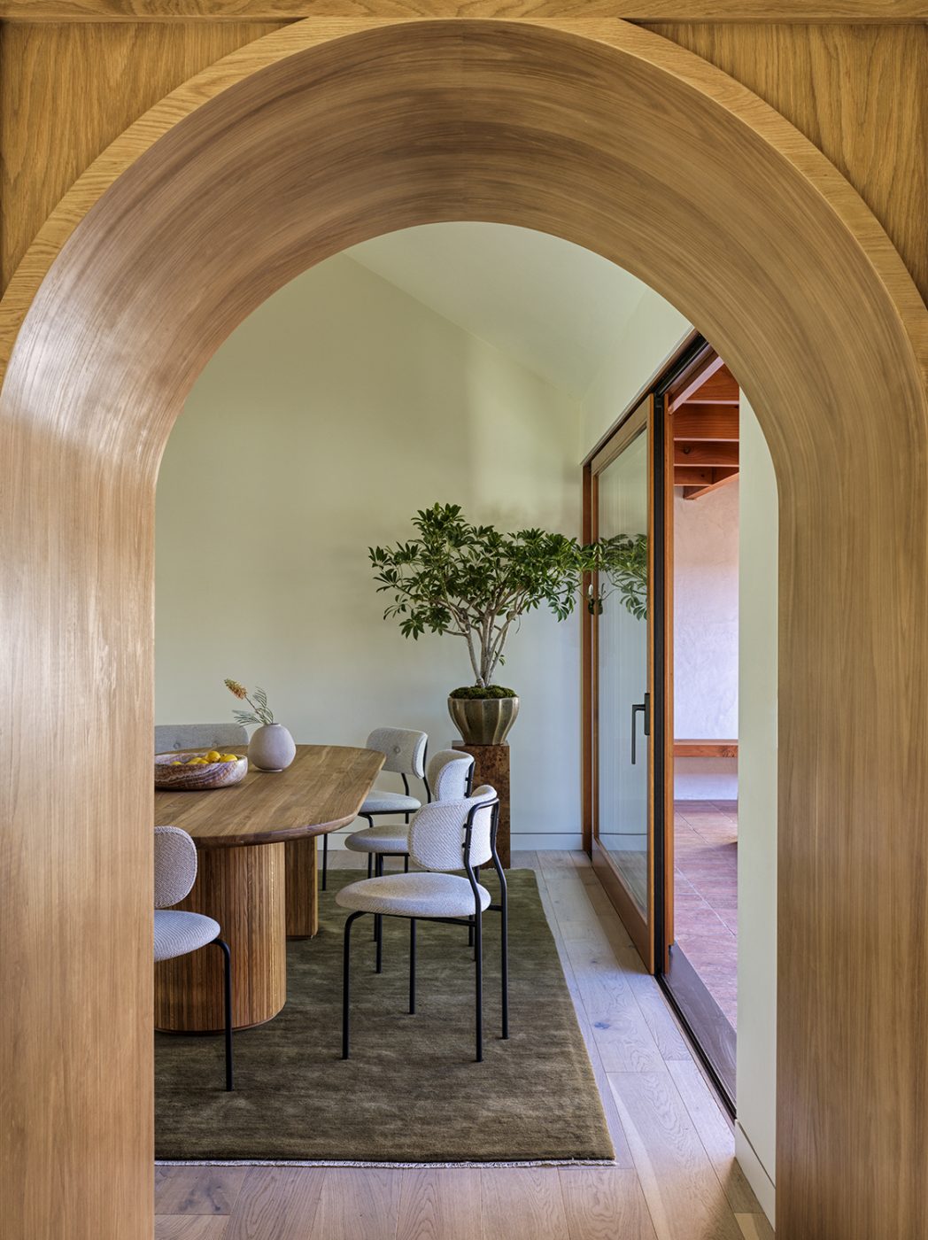 A view through an archway into the dining room of a home designed by And And And Studio in L.A.'s Beverlywood neighborhood