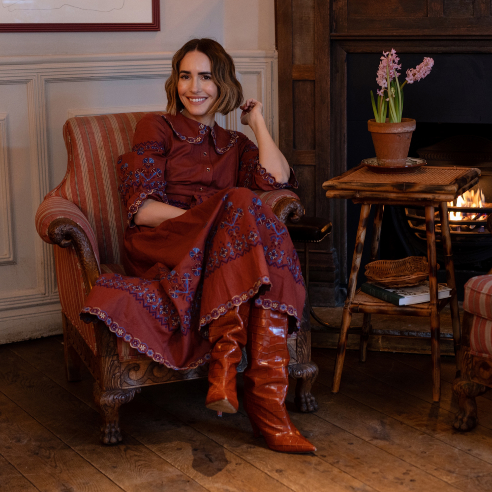 Louise Roe sits in an upholstered vintage chair by the fireplace at the Princess Royal pub in London