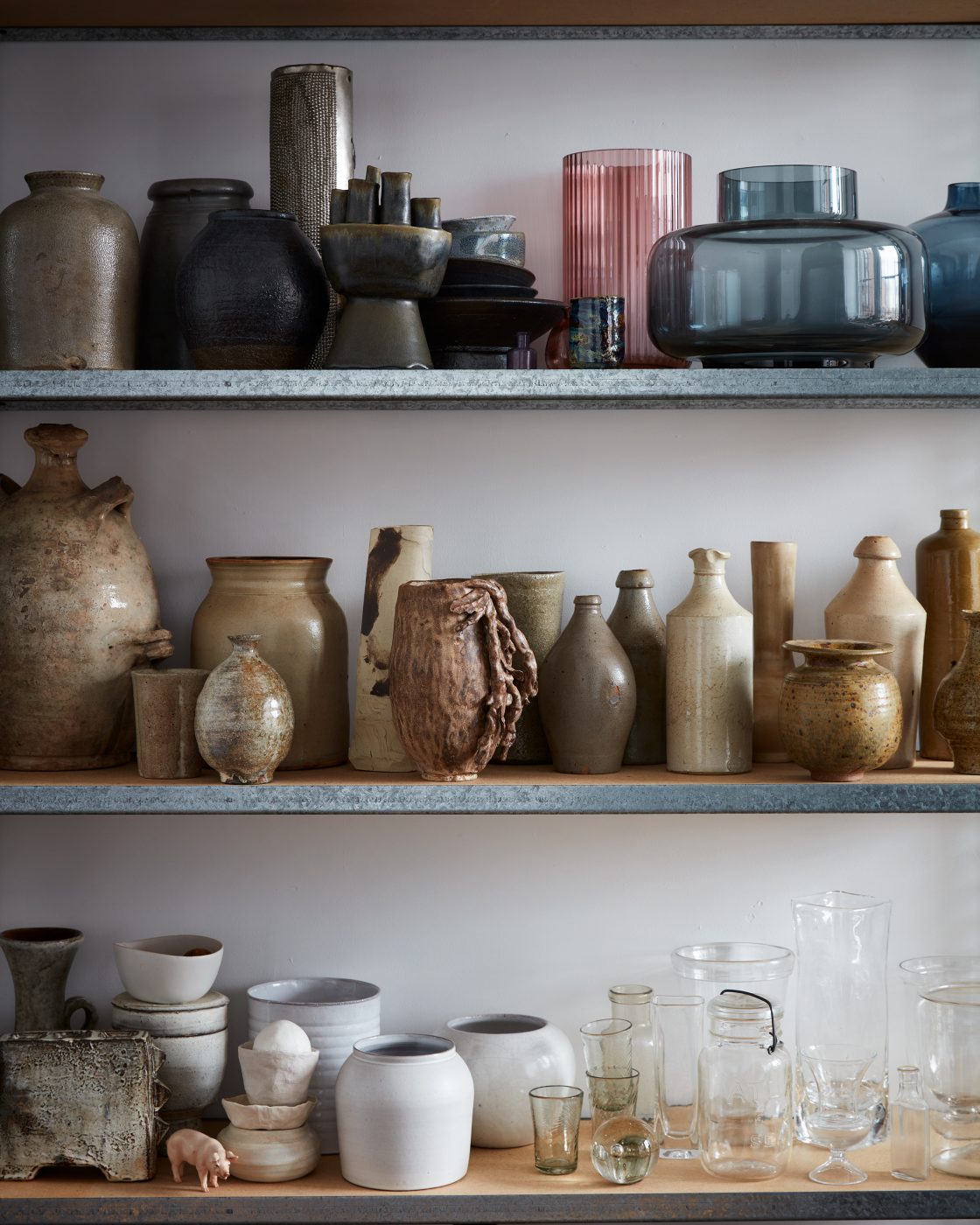 Shelves holding Lindsey Taylor's glass and ceramic vases