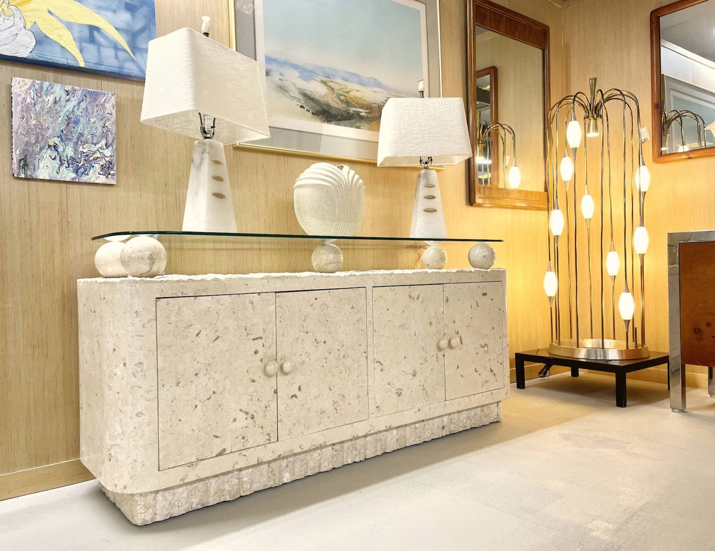 A late-20th-century Mactan stone buffet, a pair of 1950s alabaster lamps and 1970s Lightolier floor lamp in the showroom at Furnish Me Vintage