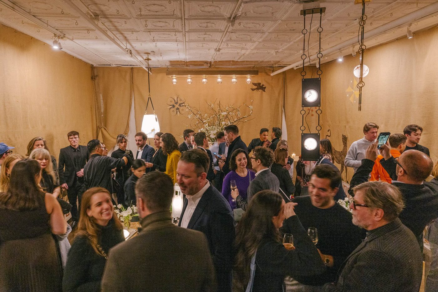 Guests mingle in the Remains Lighting Company's Manhattan showroom during the launch party for Matthew Fisher's Ariadne lighting collection.