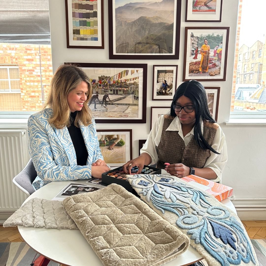 United in Design intern Aaliyah Oshodi reviews rug samples with a coworker at The Rug Company
