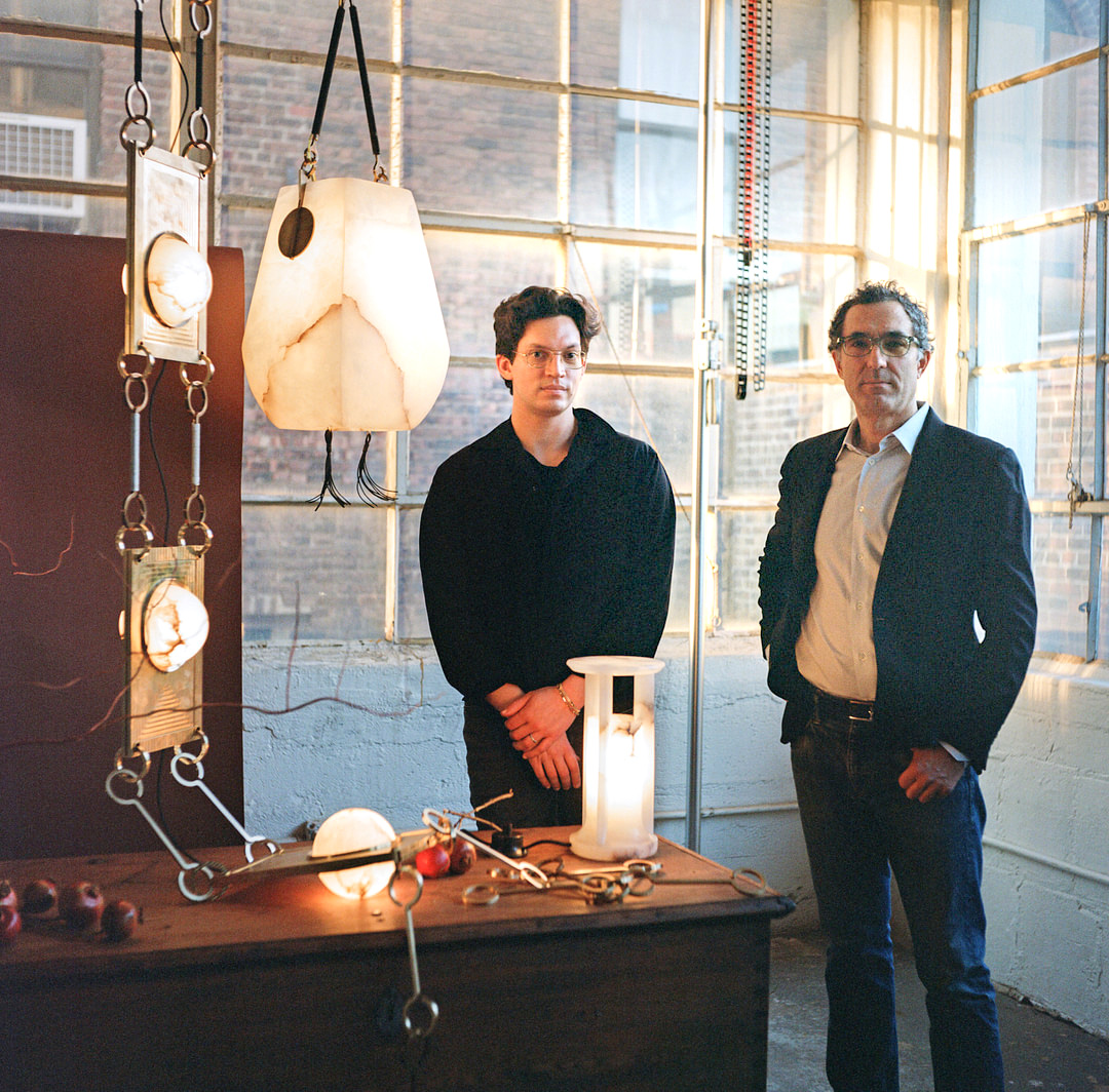 Matthew Fisher with David Calligeros of Remains Lighting Company in the company's Brooklyn factory alongside Fisher's NIMA DROP CHANDELIER, KALATHI LANTERN and ARIADNE TABLE LANTERN 