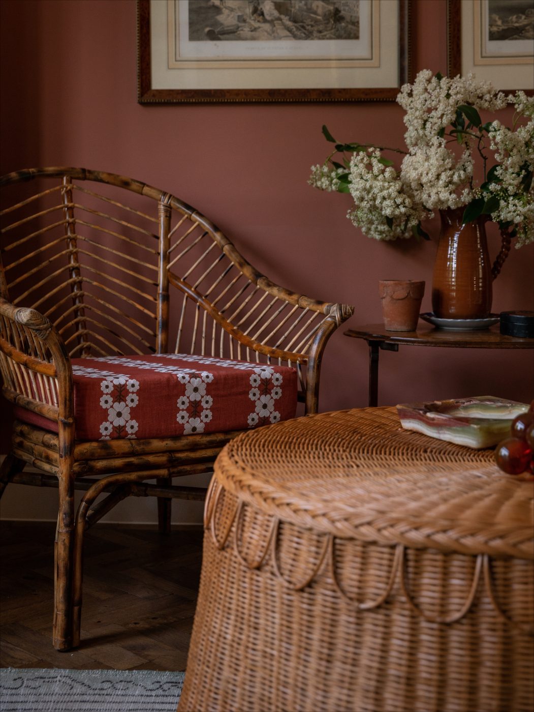 The Sharland England Piolo chair, with a brick red floral cushion, and the company's Adeline rattan coffee table in Louise Roe's London home