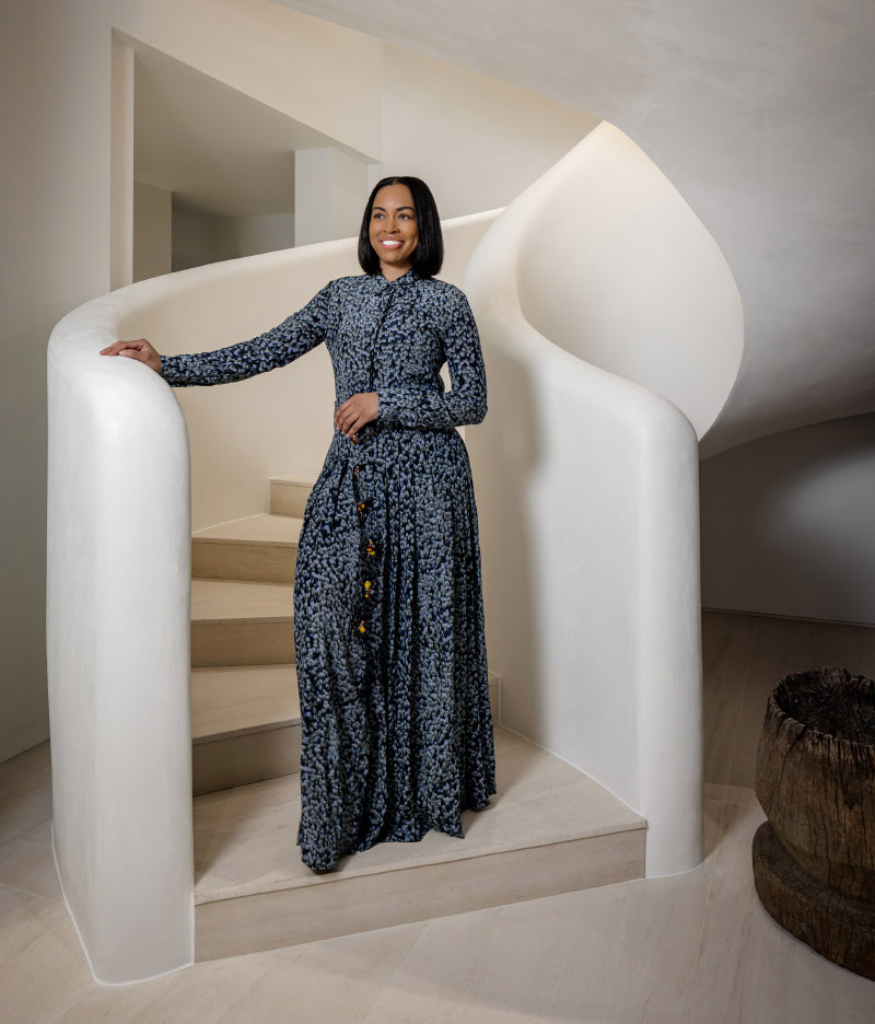 Portrait of Duett Interiors' Tiffany Thompson on the sculptural staircase of a Miami home she designed for an NBA player and his family