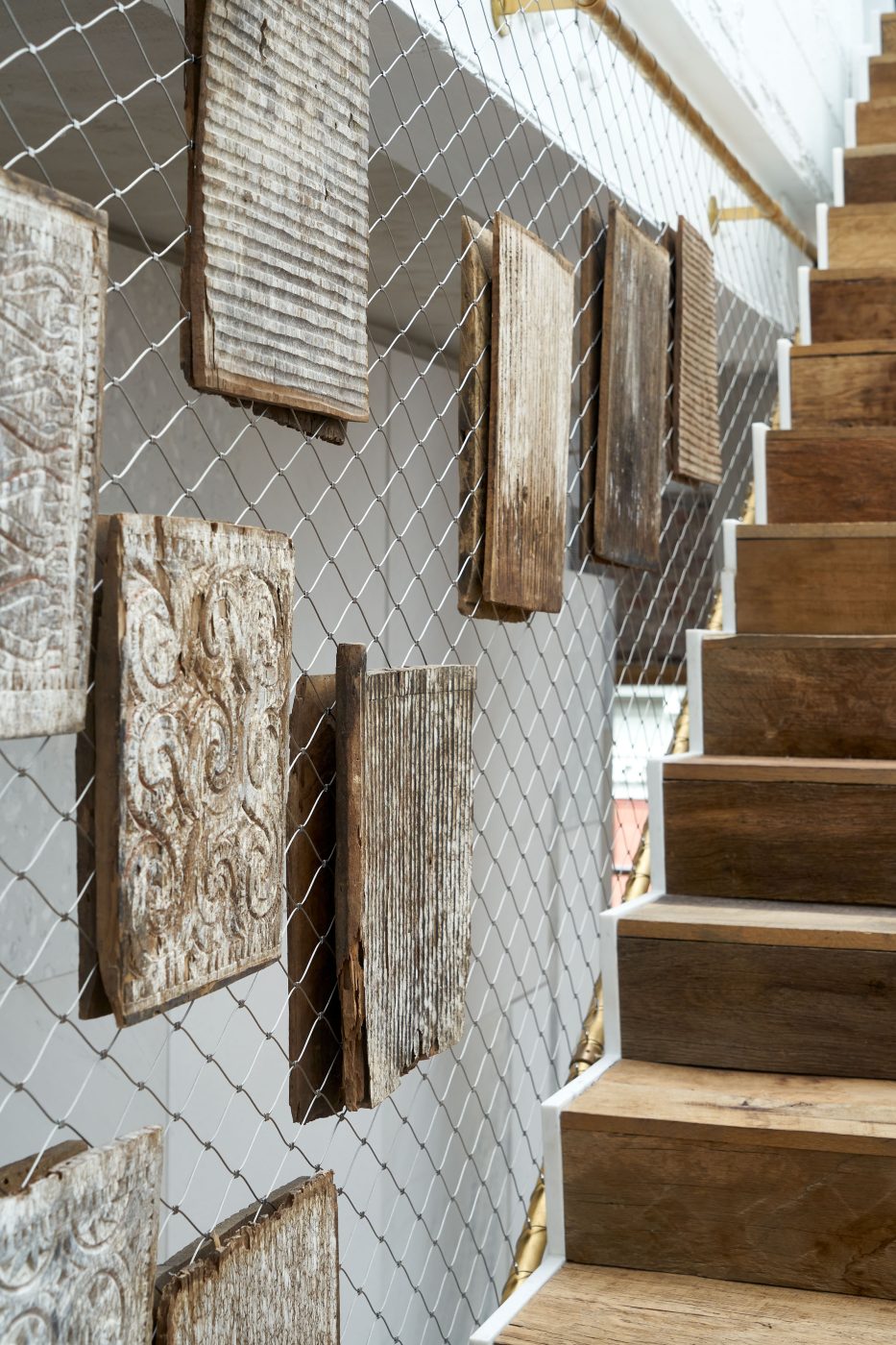 Wine fencing and Torajan panels line the staircaese in the Soho loft of Andrianna Shamaris