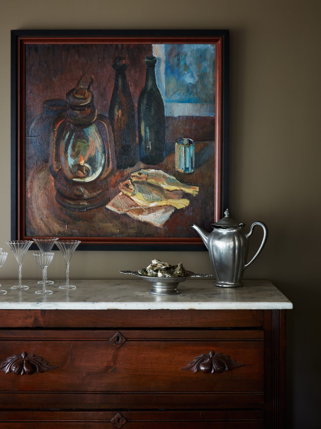 Ukranian tabletop still-life painting hung over marble-topped sideboard in dining room of interior designer Molly Beth Kidd's Oregon home