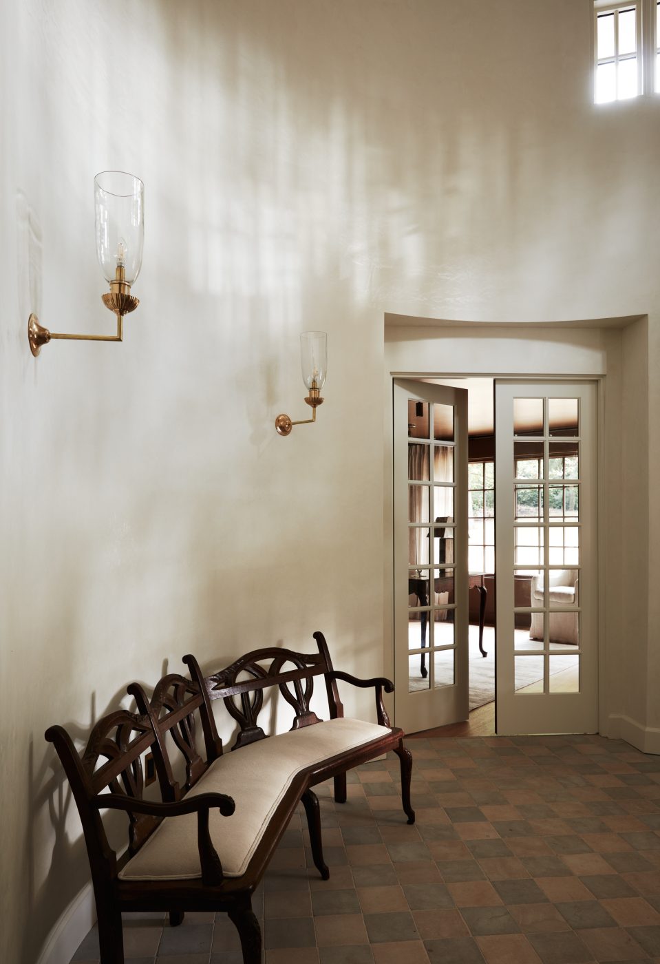 angled antique bench in rounded double height foyer of interior designer Molly Beth Kidd's Oregon home