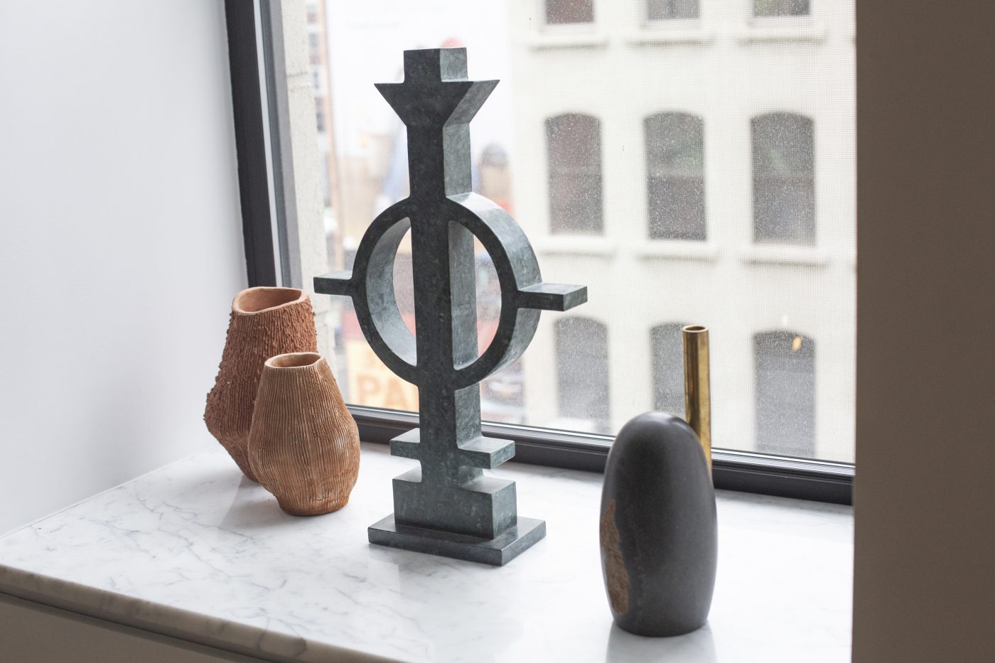 Vases and candleholders on a window sill at Galerie Philia