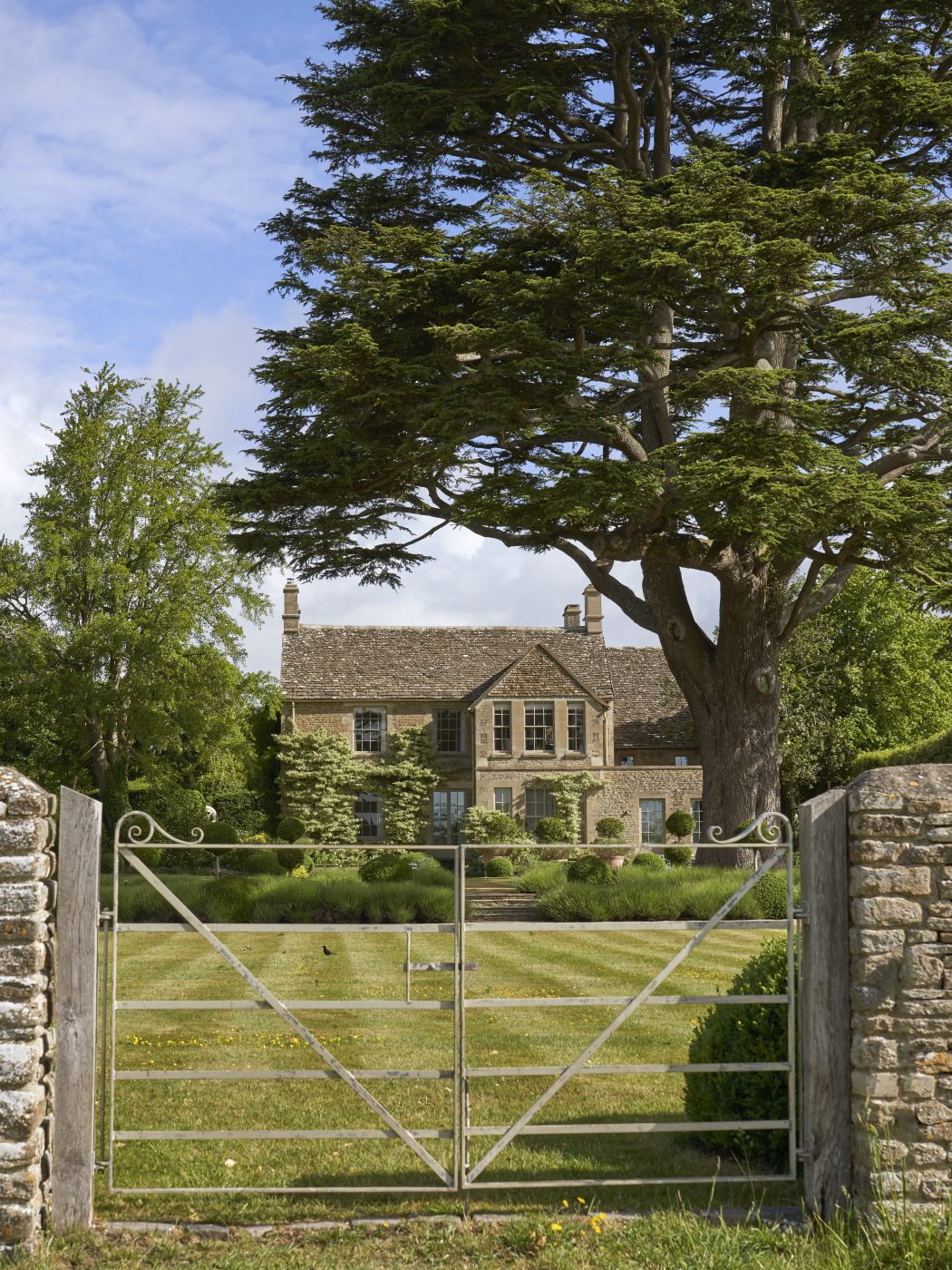 Exterior of the golden-stone-walled Lodge at the Thyme countryside hotel and estate in England's Cotswolds 