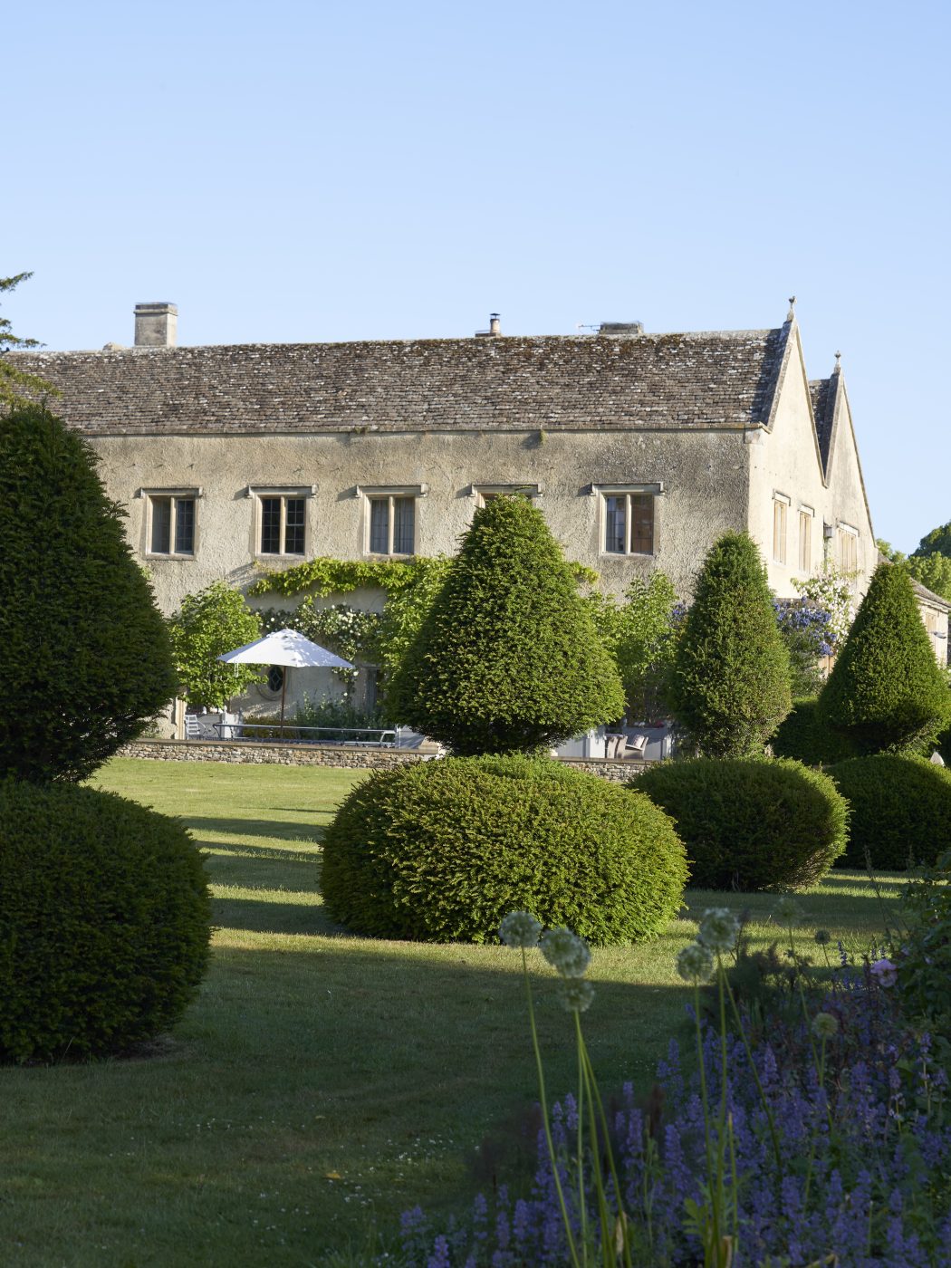 Exterior of the golden-stone-walled Manor House of the Hibbert family, founders of the Thyme countryside hotel and estate in England's Cotswolds 