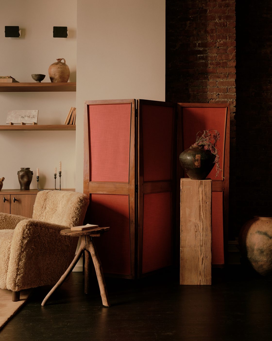 Red folding screen and fuzzy chair in living area of Flatiron District loft in New York City Manhattan designed by Lauren Garrett's firm LP Creative