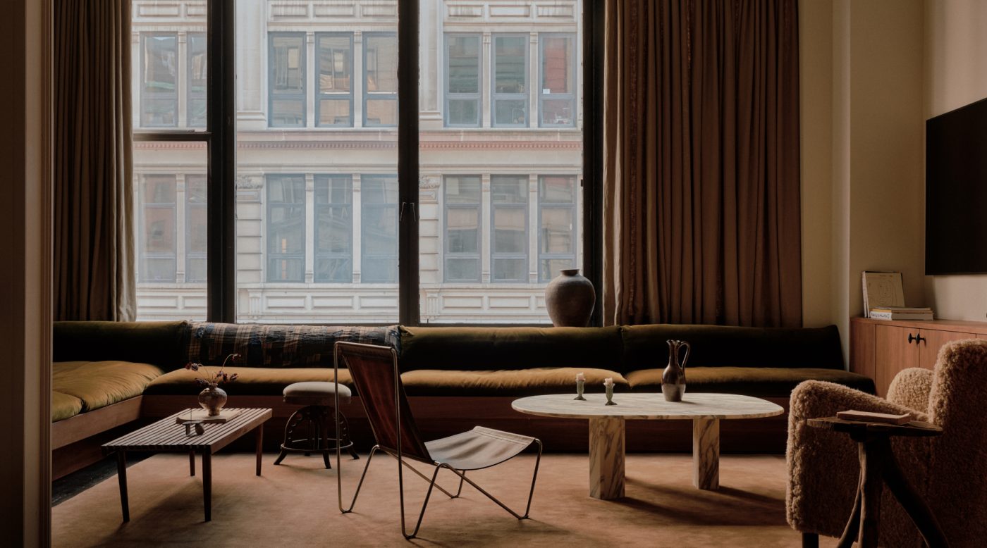 long low slung corner section sofa olive green velvet in living area of Flatiron District loft in New York City Manhattan designed by Lauren Garrett's firm LP Creative