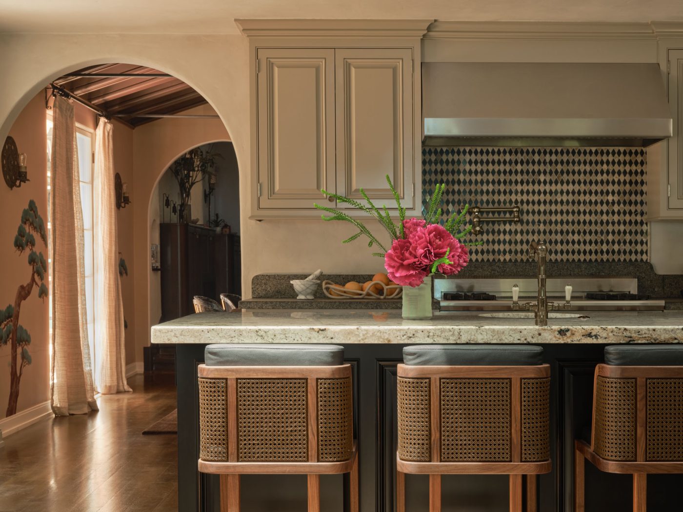 Kitchen with cane-backed bar stool at island in Palo Alto Silicon Valley California Mediterranean house designed by Mandy Cheng