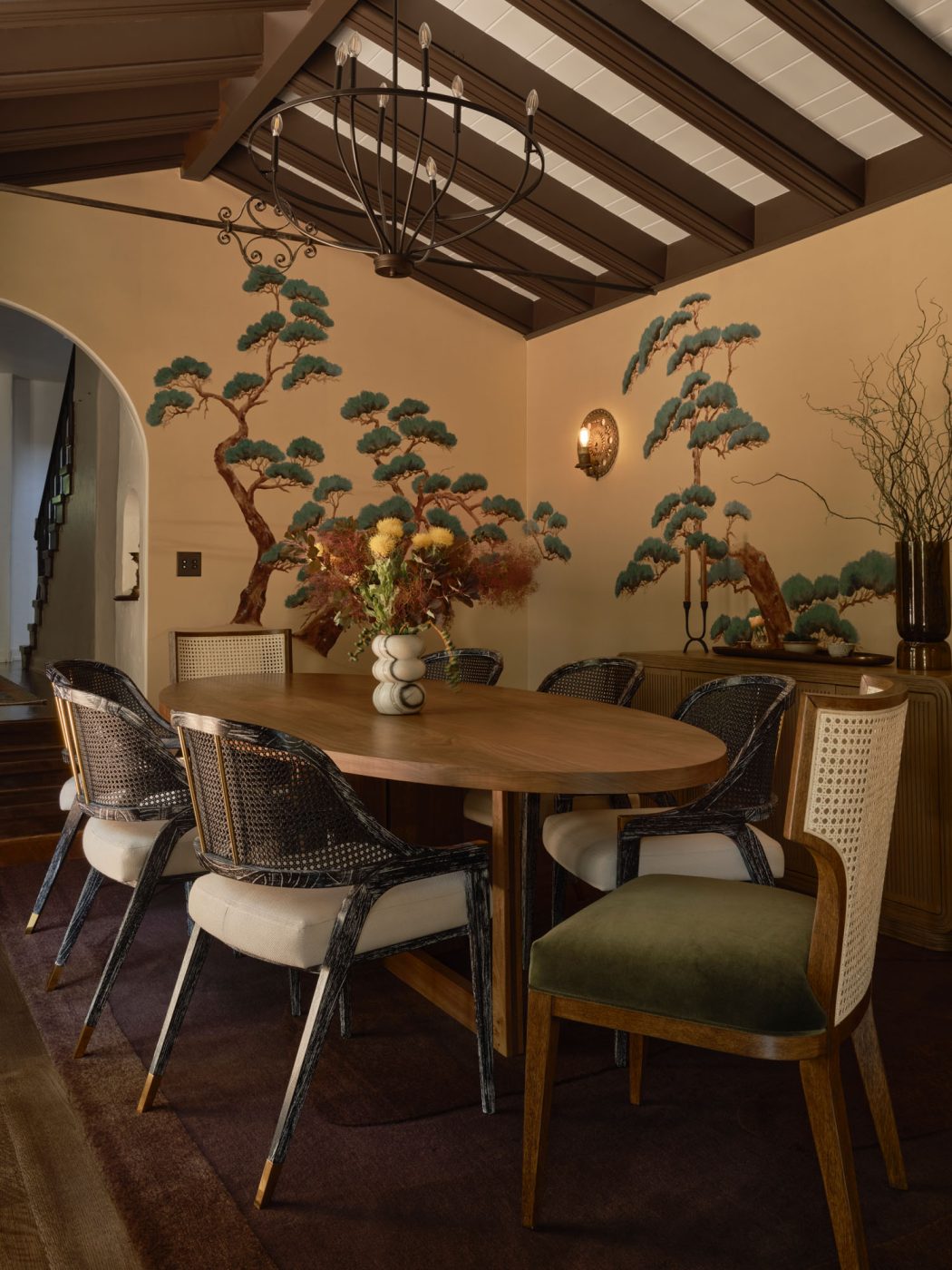 Dining room with cane-backed chairs surrounding oval wood table in Palo Alto Silicon Valley California Mediterranean house designed by Mandy Cheng