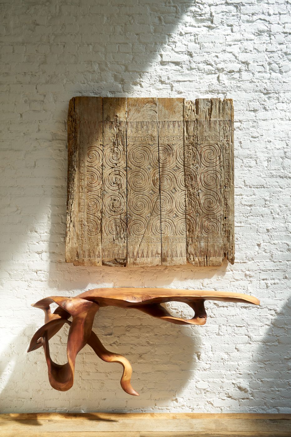 A floating teak-root console table and peace and happiness panel  in the Soho loft of Andrianna Shamaris