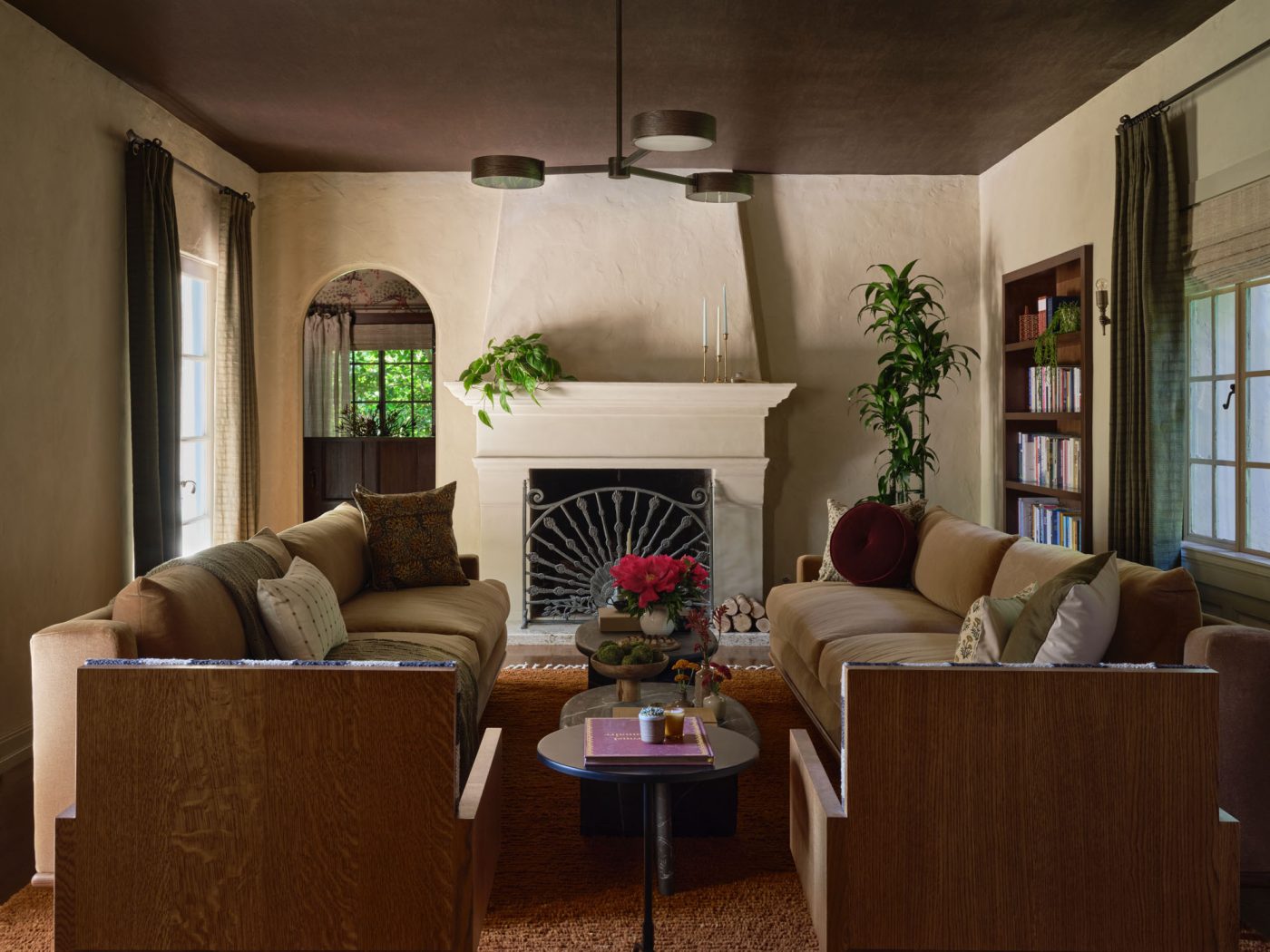Living room with twin sofas flanking a series of marble coffee tables in front of fireplace in Palo Alto Silicon Valley California Mediterranean house designed by Mandy Cheng