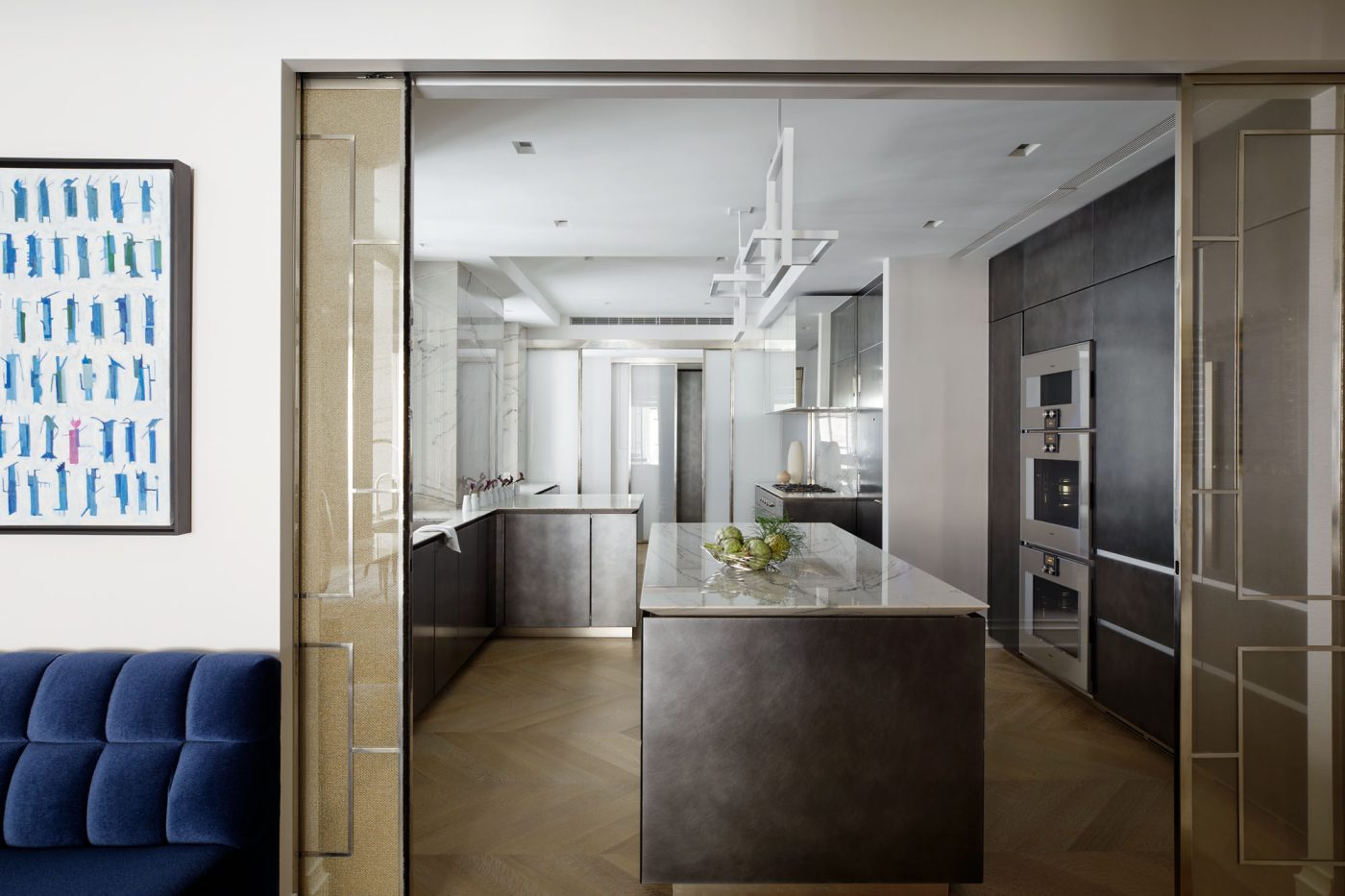 View of silvery-hued kitchen behind sliding doors in Fifth Avenue Manhattan apartment designed by David Kleinberg
