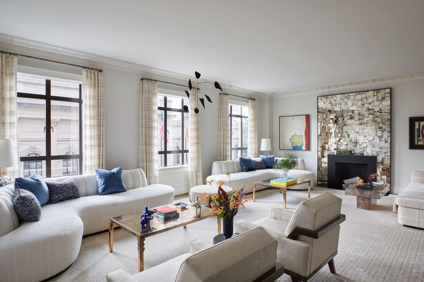 Living room with mirrored fireplace surround in Fifth Avenue Manhattan apartment designed by David Kleinberg