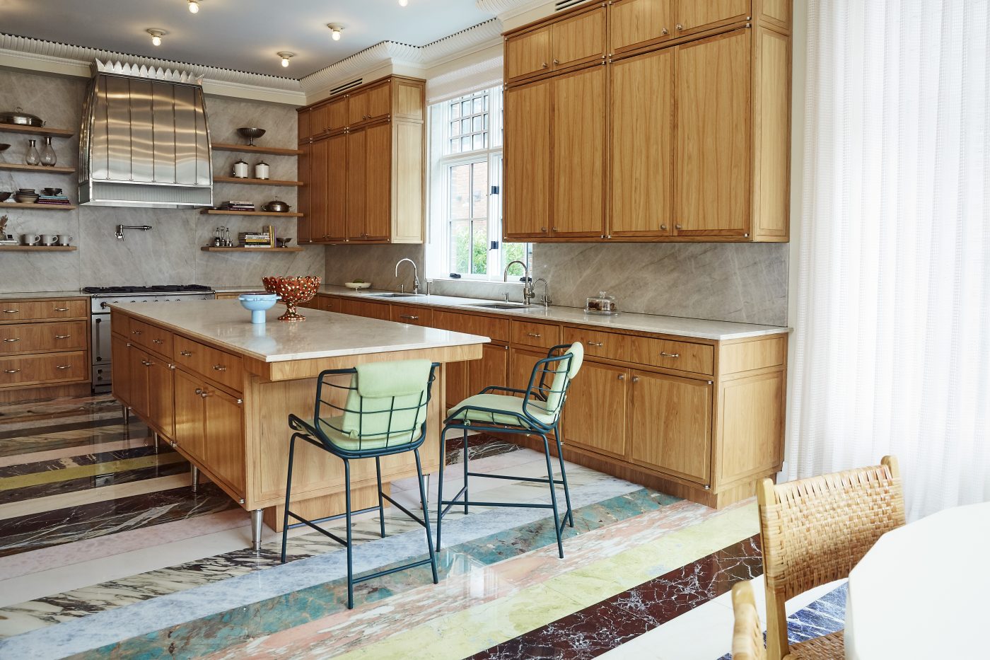Kitchen with marble striped floors and counter stools by Giacomo Cattani in a home in Brooklyn's Gravesend neighborhood with interior design by Eli Dweck 