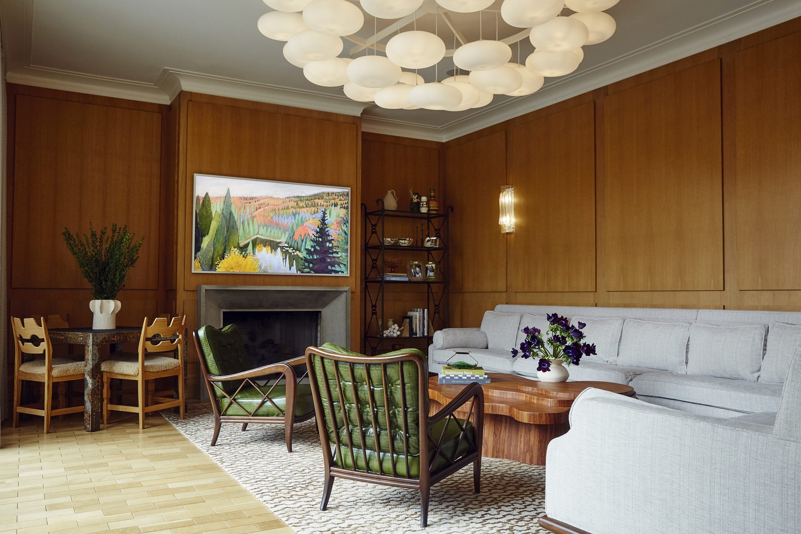Paolo Buffa chairs, sectional sofa, amorphous-shapped coffee table, fireplace and games table  in den of Brooklyn's Gravesend neighborhood with interior design by Eli Dweck 