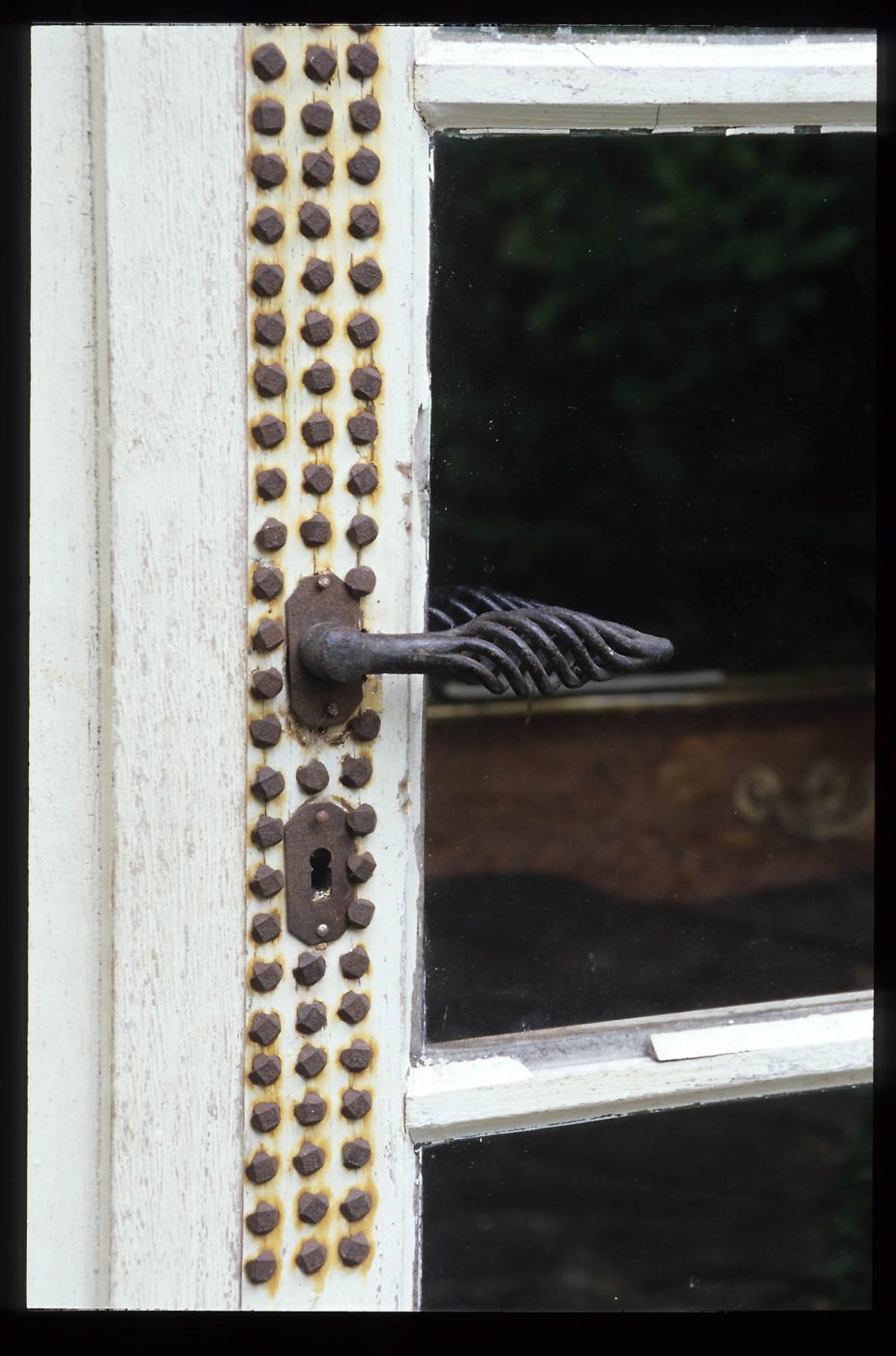 A door with a nailhead design above and below the door handle at Jean Royère's house in Brittany