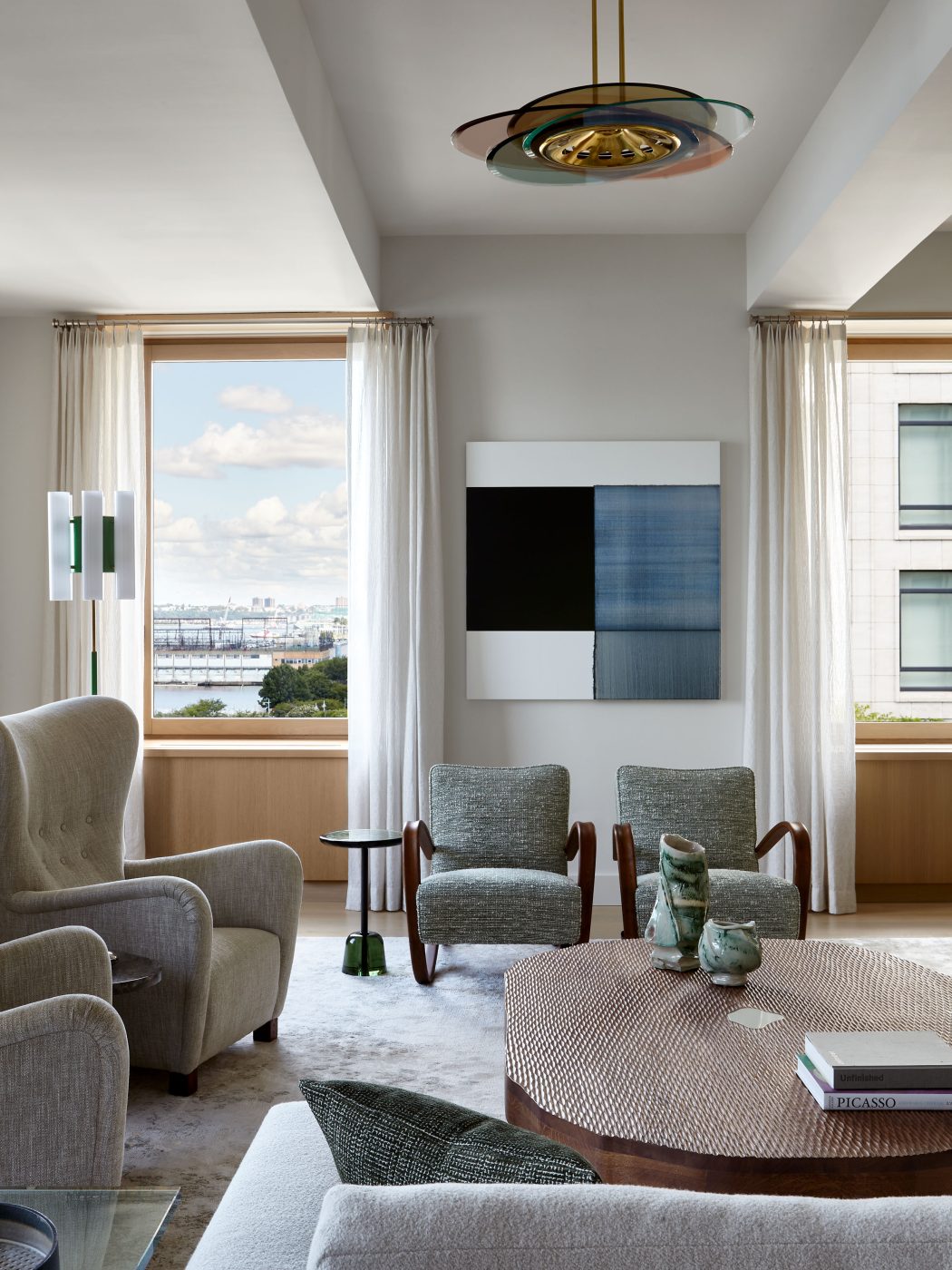 Great room with Gio Ponti coffee table, sectional sofa, pair of Jindřich Halabala wing chairs and rosewood armchairs by Jorge Zalszupin in Tribeca Manhattan New York loft designed by Damon Liss