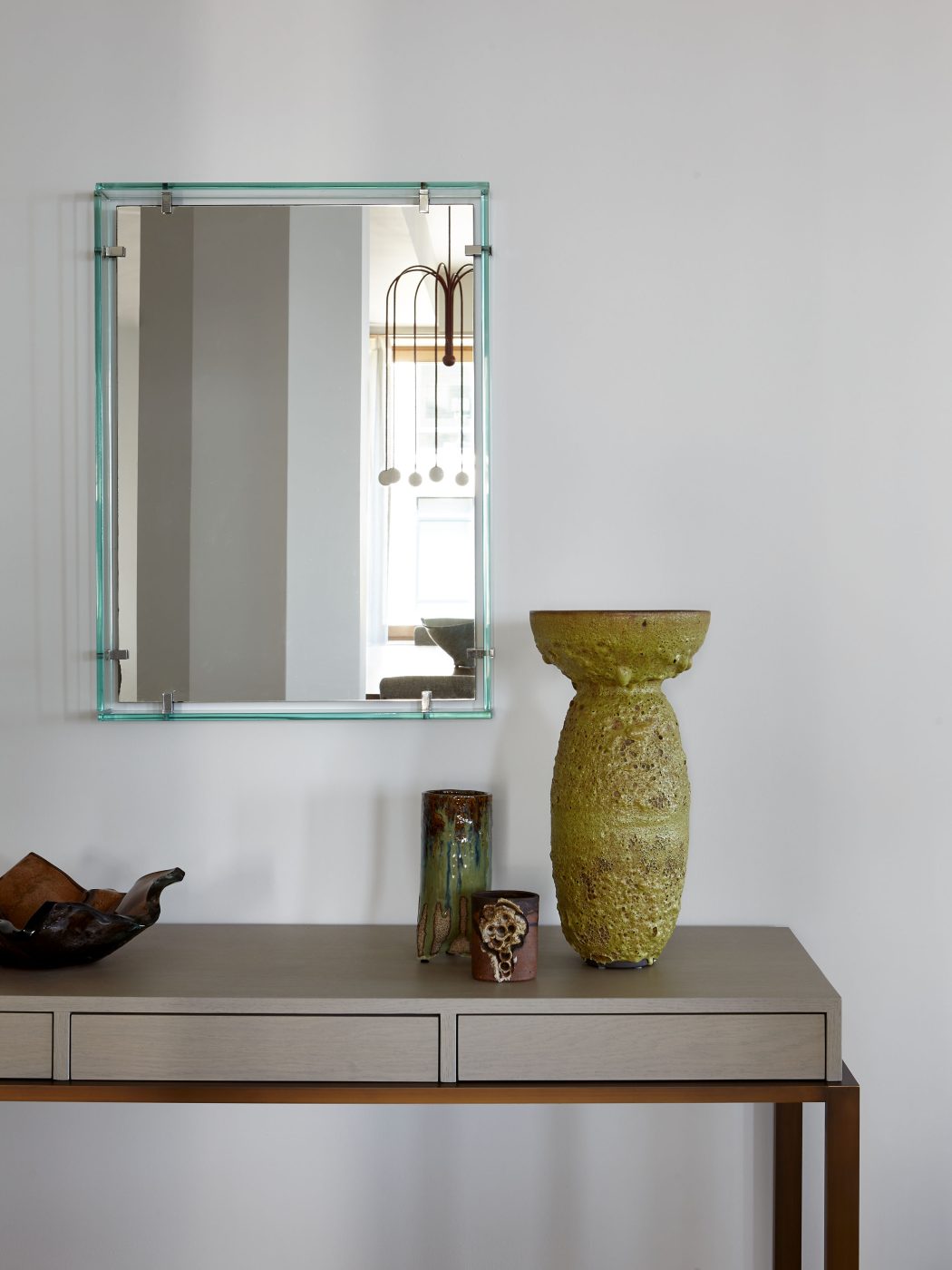 Max Ingrand for Fontana Arte mirror over oak-and-bronze console topped by glazed-stoneware vase by Adam Silverman in Tribeca Manhattan New York loft designed by Damon Liss