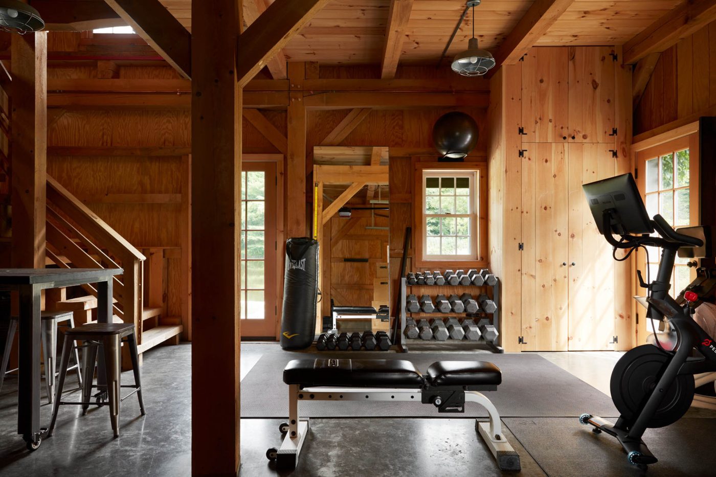 Shawn Henderson kept things utilitarian in the gym: poured-concrete floor, “free weights and a bench I’ve had for many years,” he says, plus a rowing machine and a Peloton stationary bike, under a galvanized-steel industrial lights.