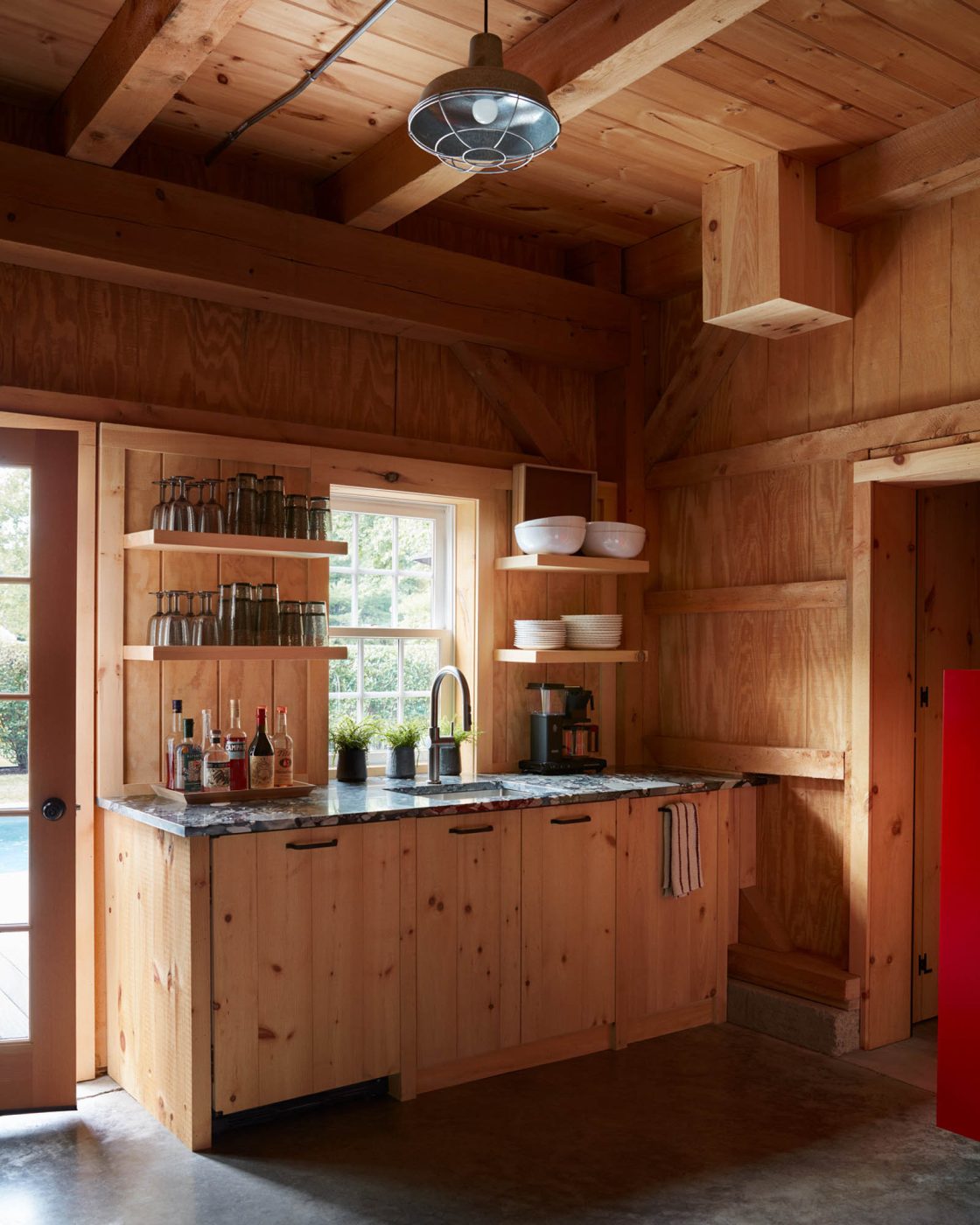A reminder of Adirondack camp living is the open shelving above the kitchenette.