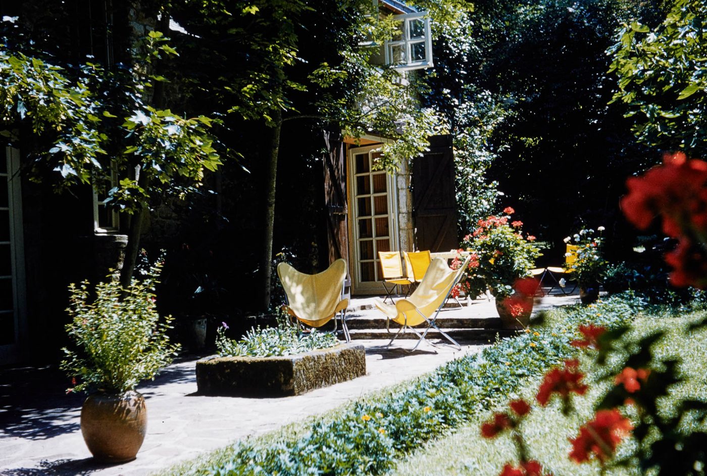 A pair of yellow butterfly chairs in the garden of Jean Royère's home in Brittany