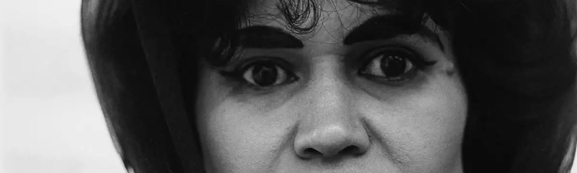 A closeup of a black-and-white Diane Arbus photograph of a woman wearing a hair scarf