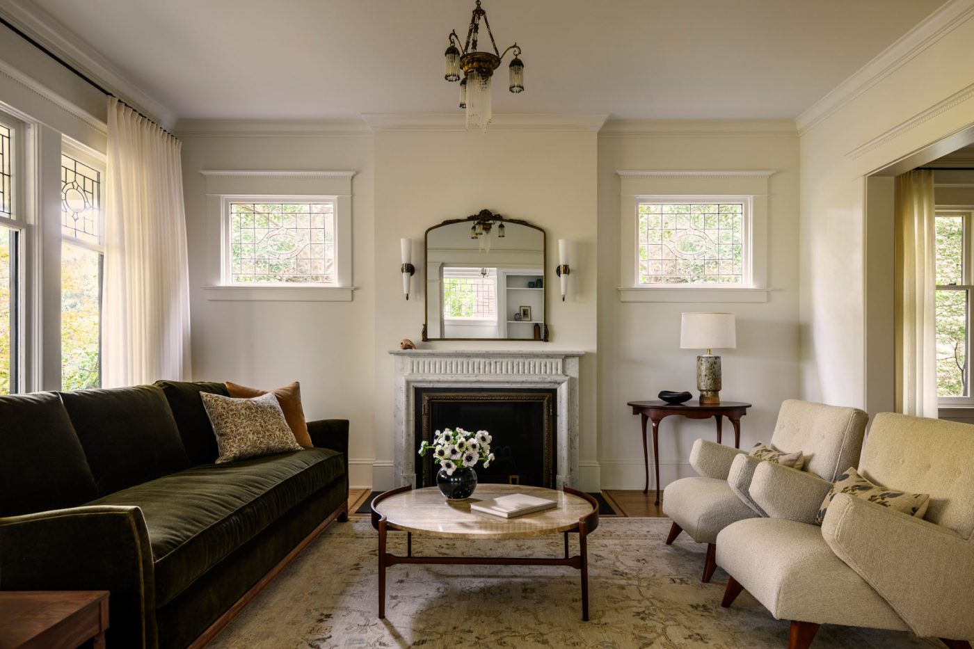 Living room with white marble fireplace and antique mirror above in a house in Seattle's Capitol Hill neighborhood designed by Lisa Staton