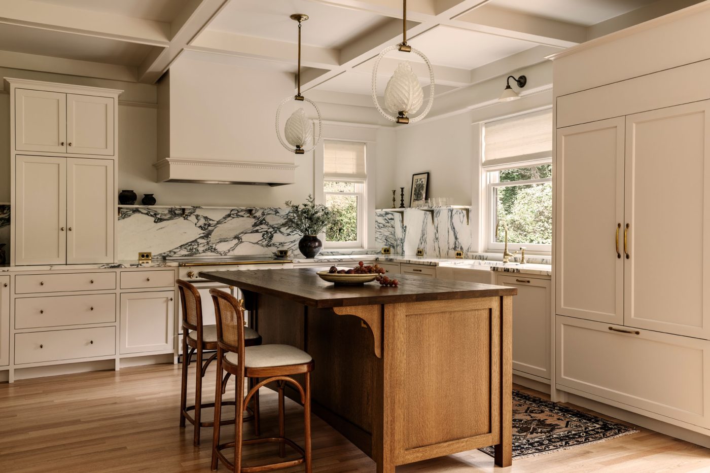 Kitchen with richly veined black and white marble counters and backsplash and ivory-painted cabinets in a house in Seattle's Capitol Hill neighborhood designed by Lisa Staton