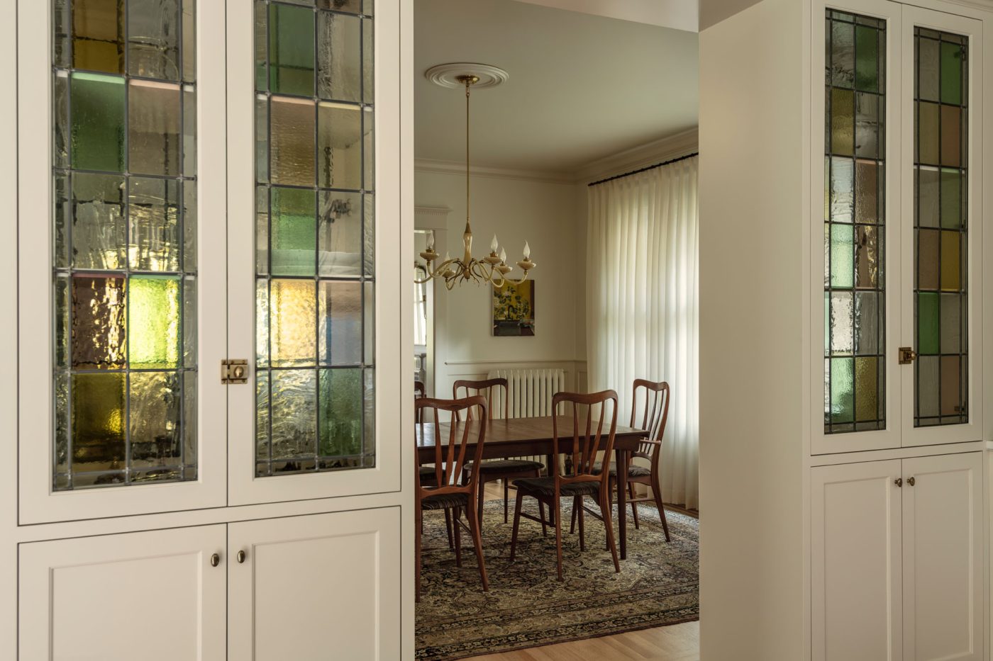View of dining room seen from opening in kitchen cabinets in a house in Seattle's Capitol Hill neighborhood designed by Lisa Staton