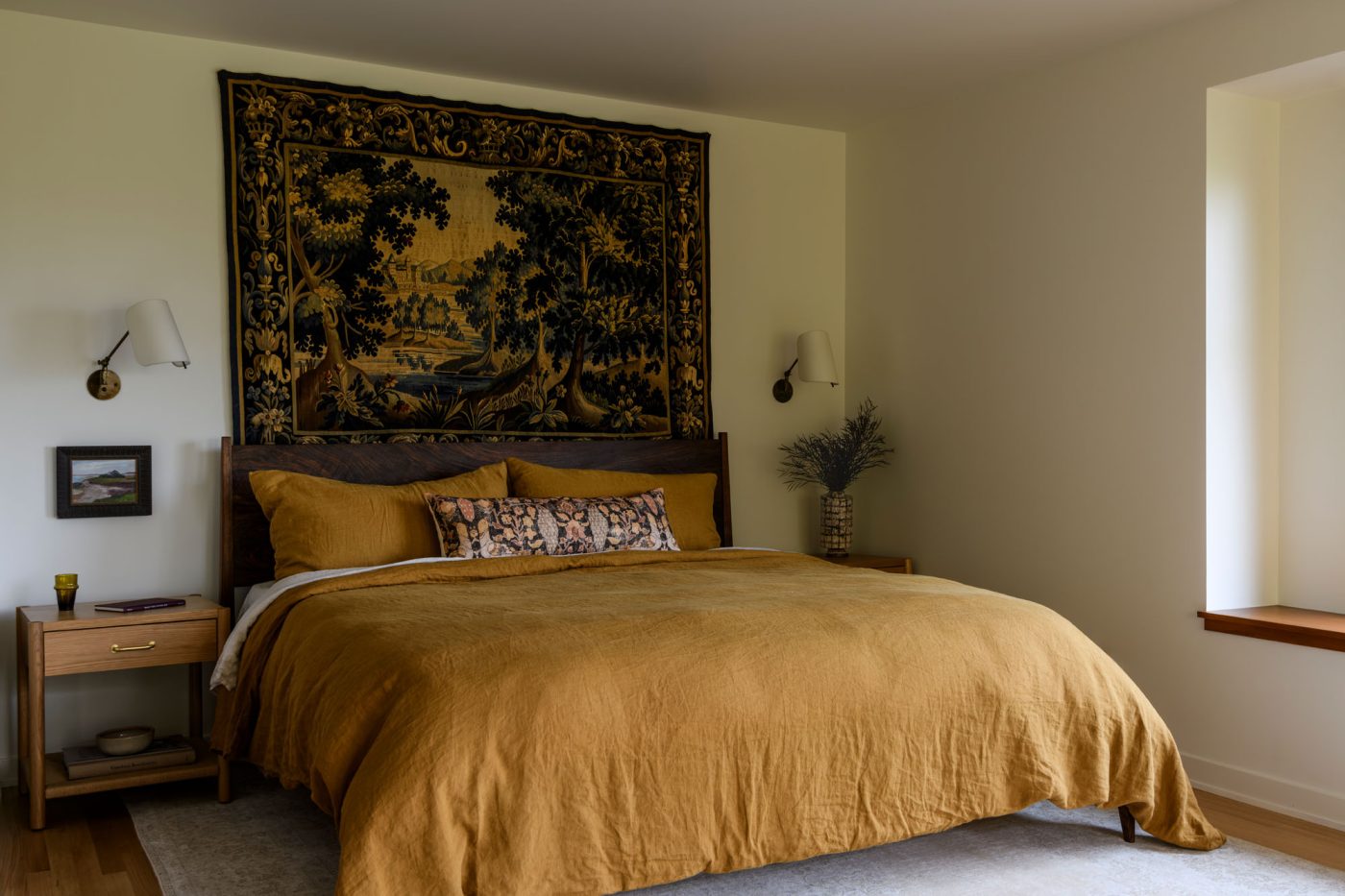 Primary bedroom with European tapestry above the wooden bed in a house in Seattle's Capitol Hill neighborhood designed by Lisa Staton