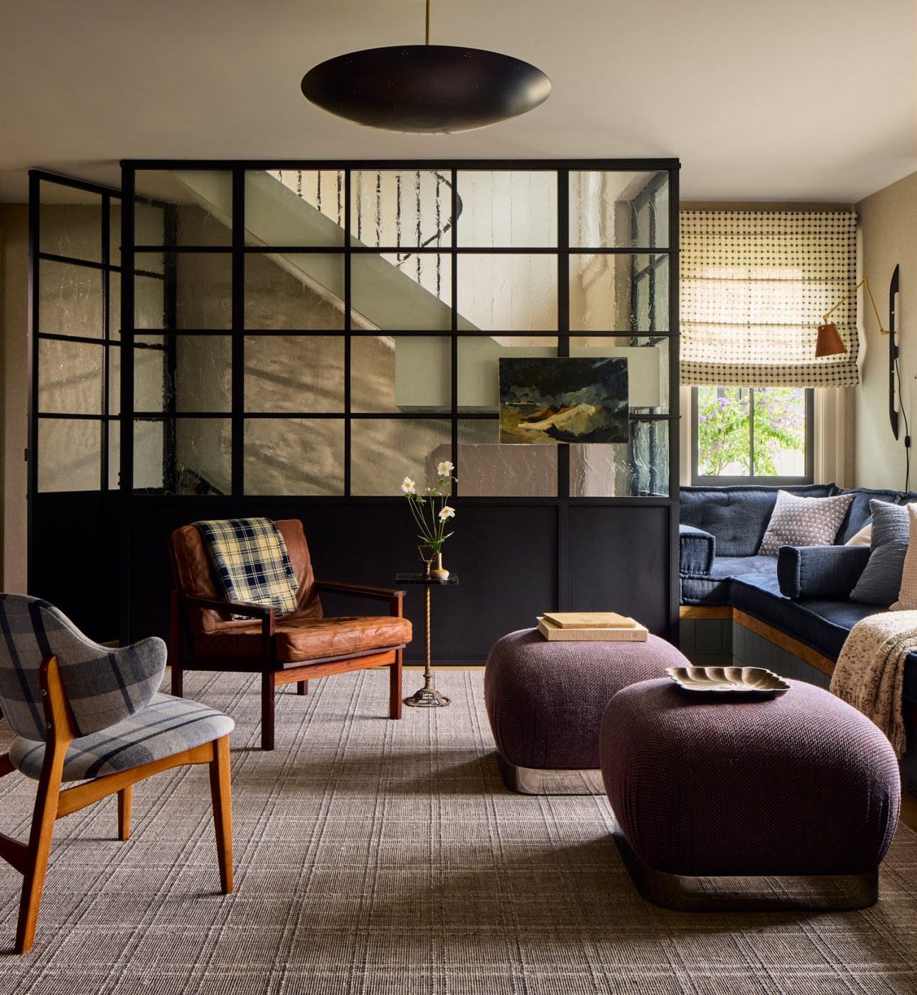 A reupholstered vintage Winnie chair from IKEA mingles with Karl Springer Souffle ottomans and a rosewood Capella armchair by Illum Wikkelsø in the den