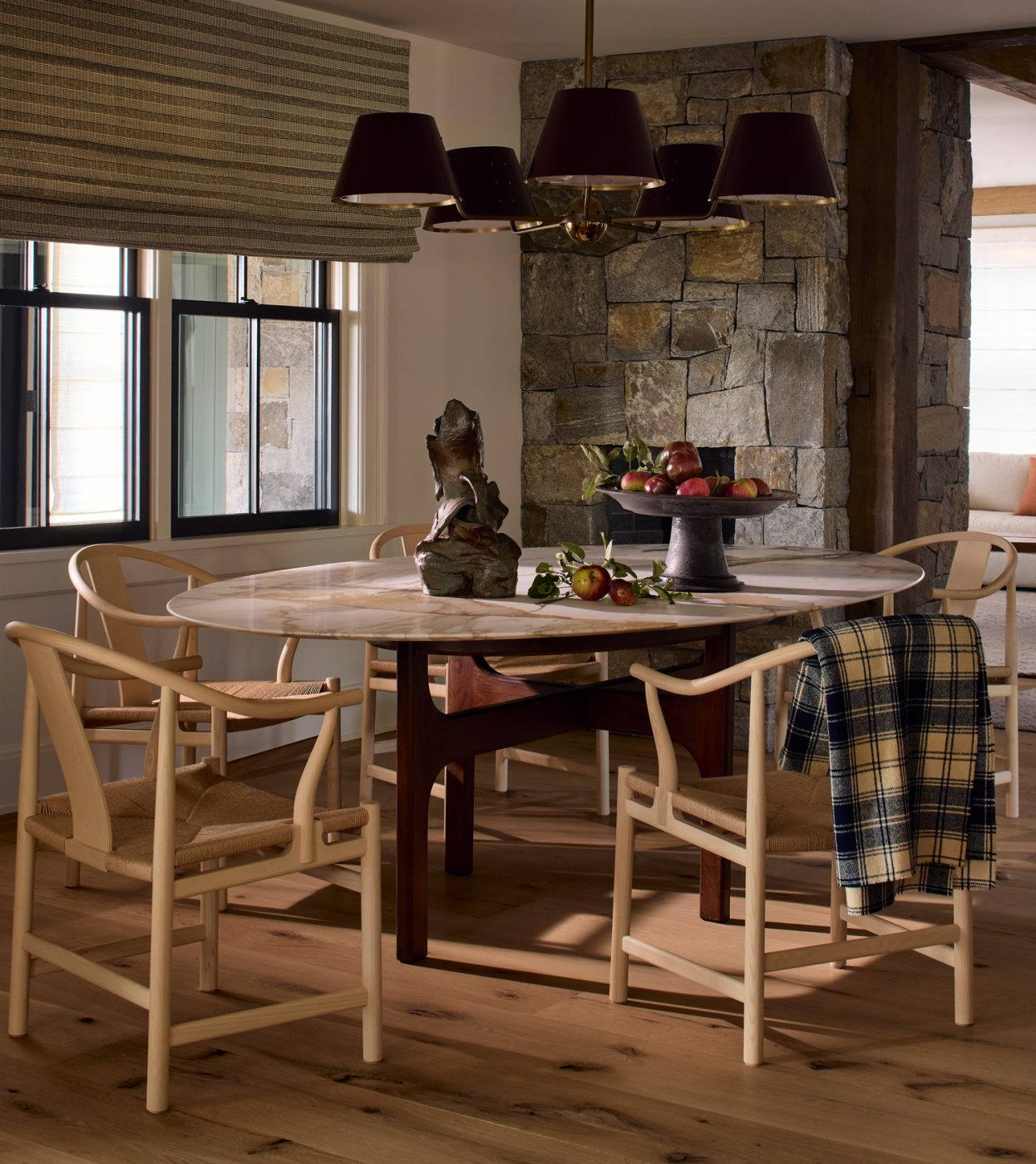 In the dining room, Hans Wegner China chairs surround a custom table with a Belgian wood base and oval marble top.