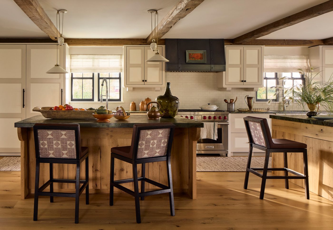 The kitchen has twin islands — one for cooking, one for dining — both topped in green marble.
