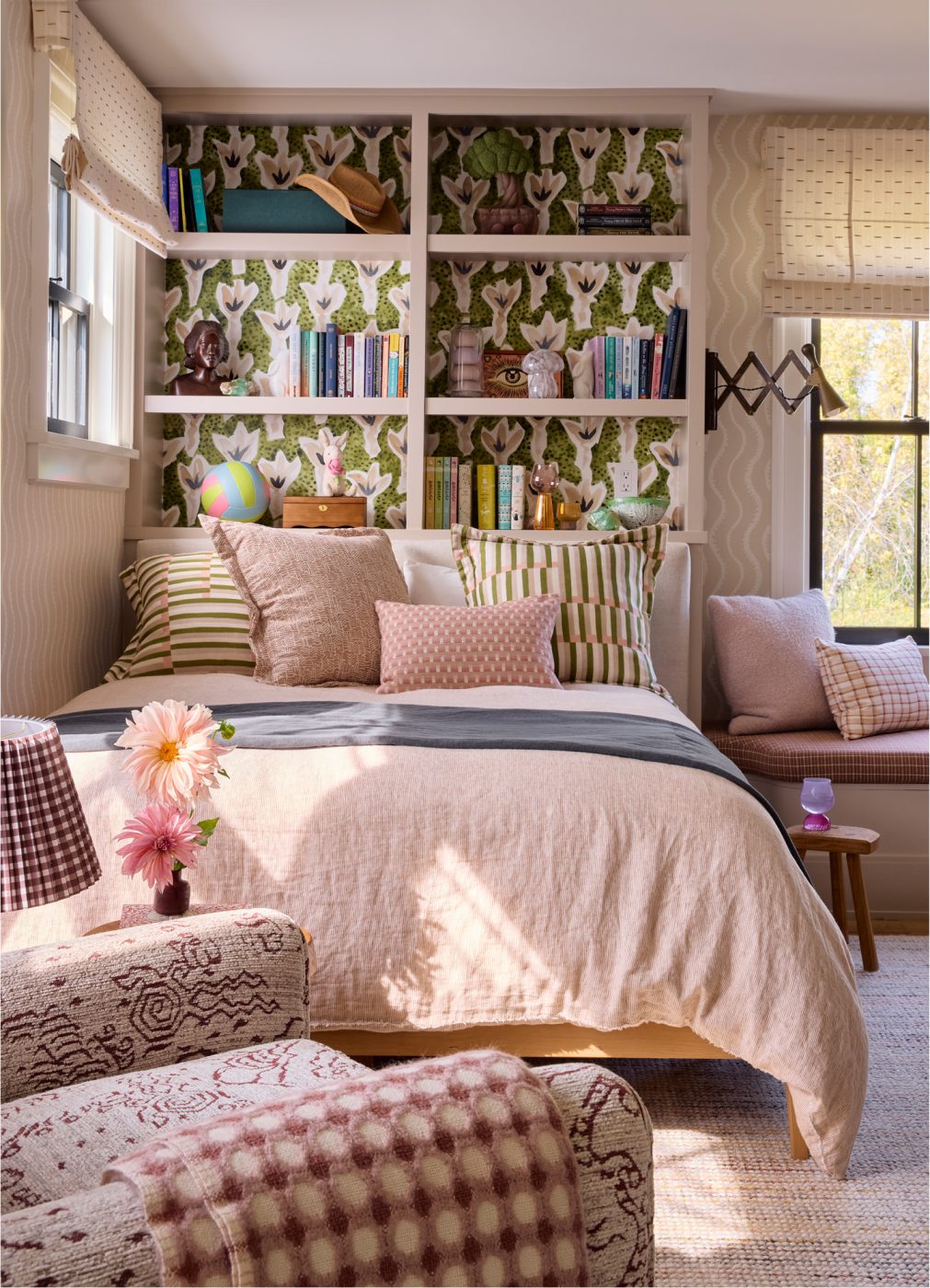 In the daughters’ shared room, a platform bed sit against a wall backed by Rebecca Atwood’s Sprigs wallpaper.
