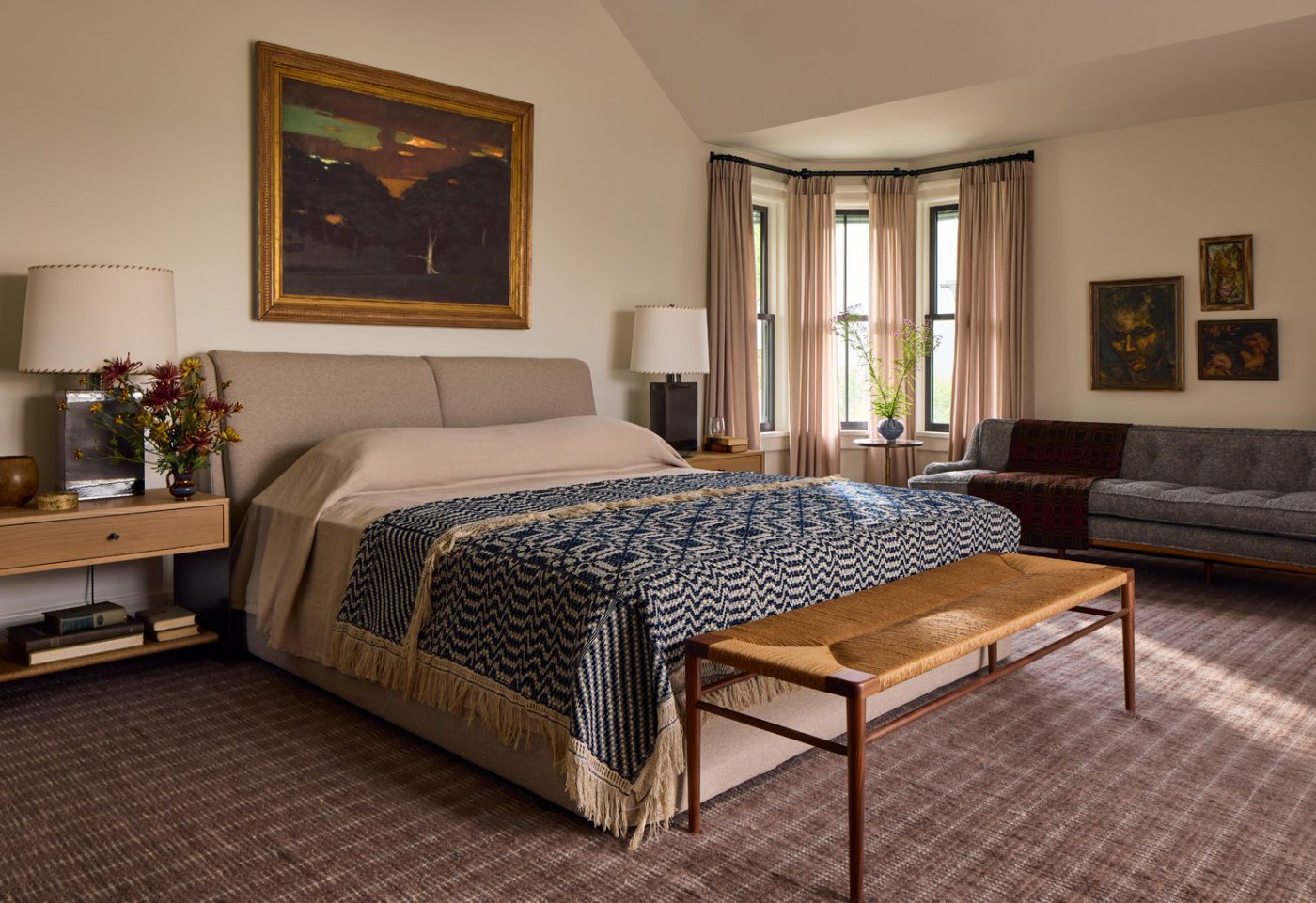 A Room and Board bed is paired with custom nightstands in the primary bedroom. Relocating the fireplace made room for a vintage American sofa reupholstered in pale blue bouclé by Rogers and Goffigon, joined by an Edward Wormley coffee table.